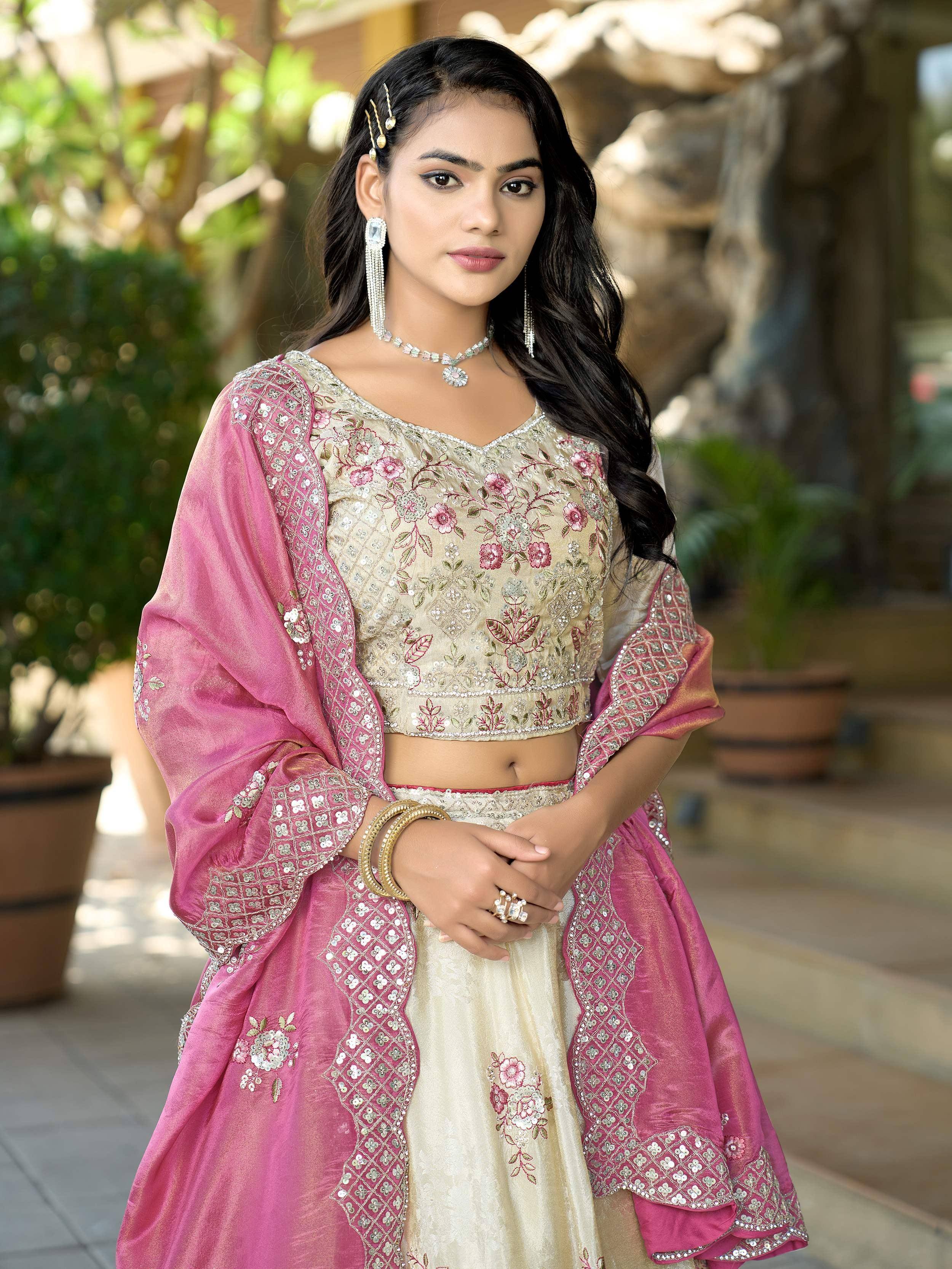 Elegant Indian lehenga choli with floral embroidery, pink dupatta, and traditional jewelry for festive occasions