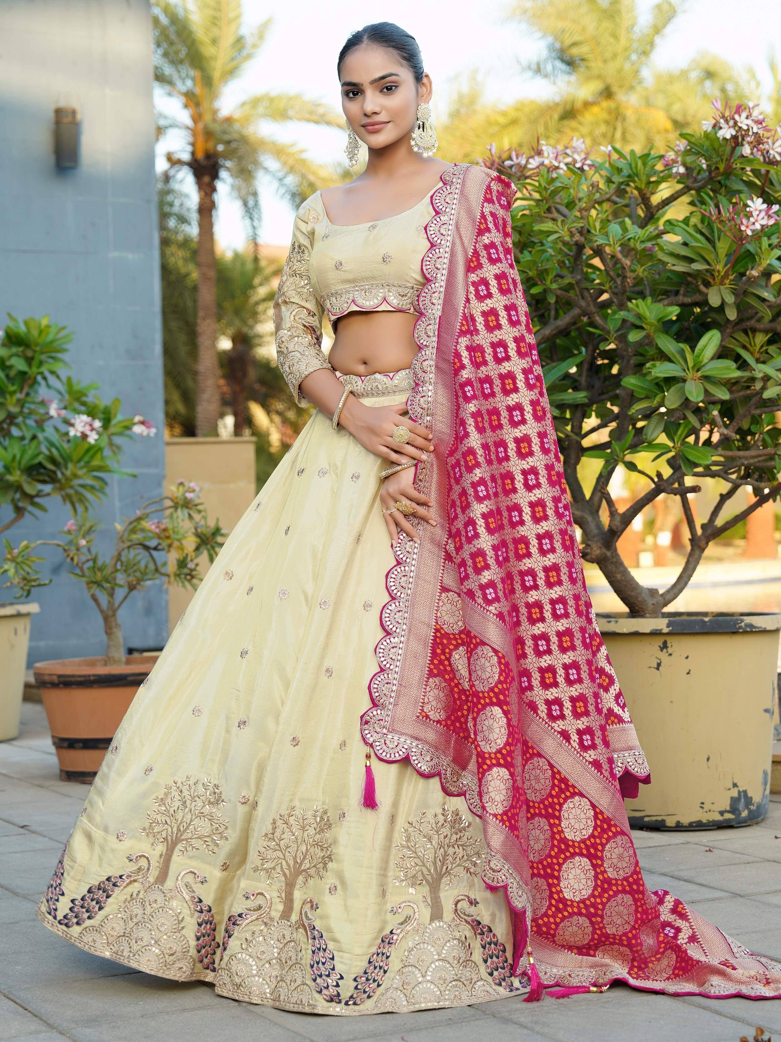 Elegant cream lehenga choli with peacock embroidery, paired with vibrant pink dupatta, perfect for Indian ethnic wear occasions.