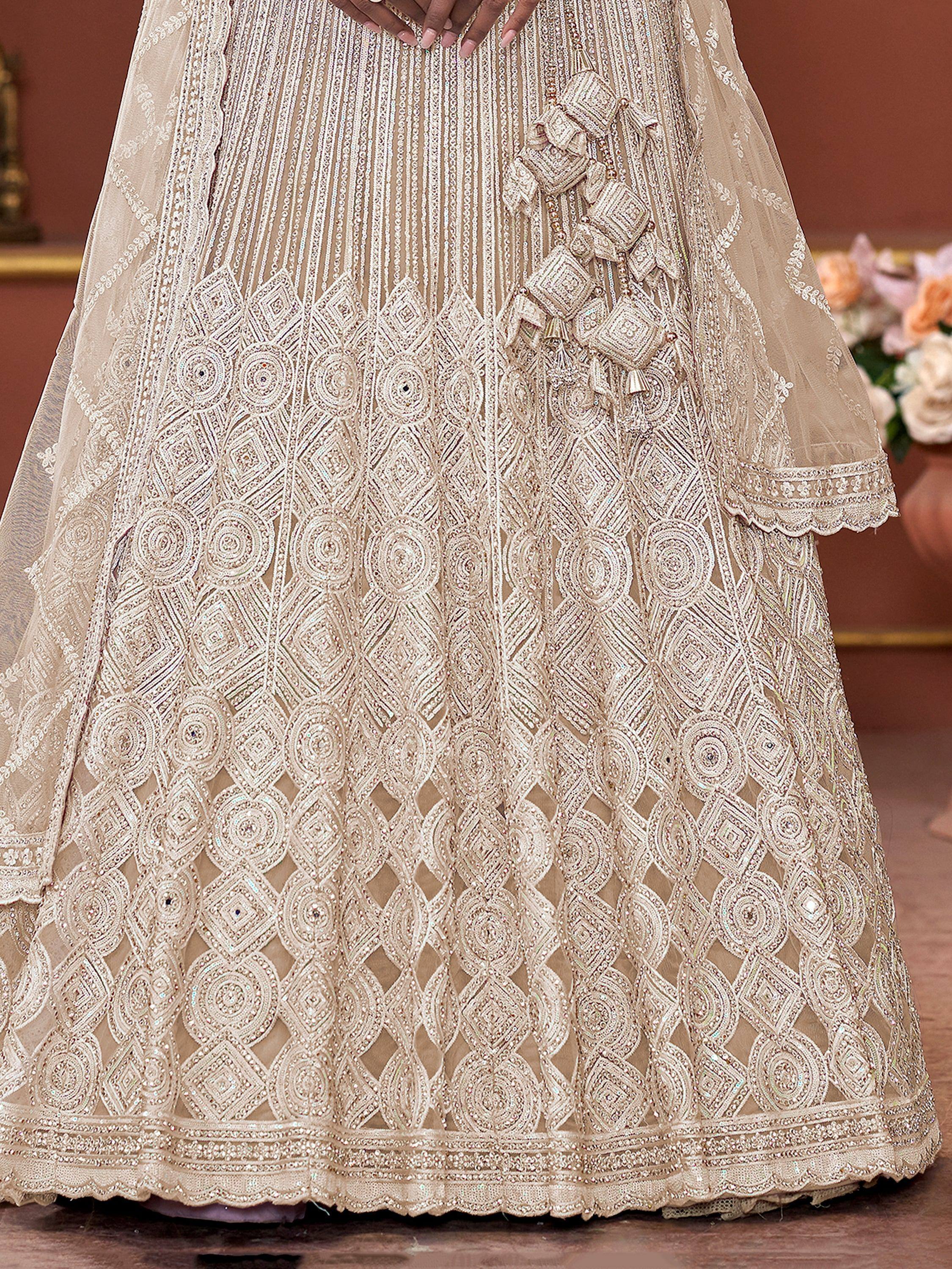 Elegant beige lehenga choli with intricate embroidery and sequin work, perfect for Indian ethnic wear occasions.