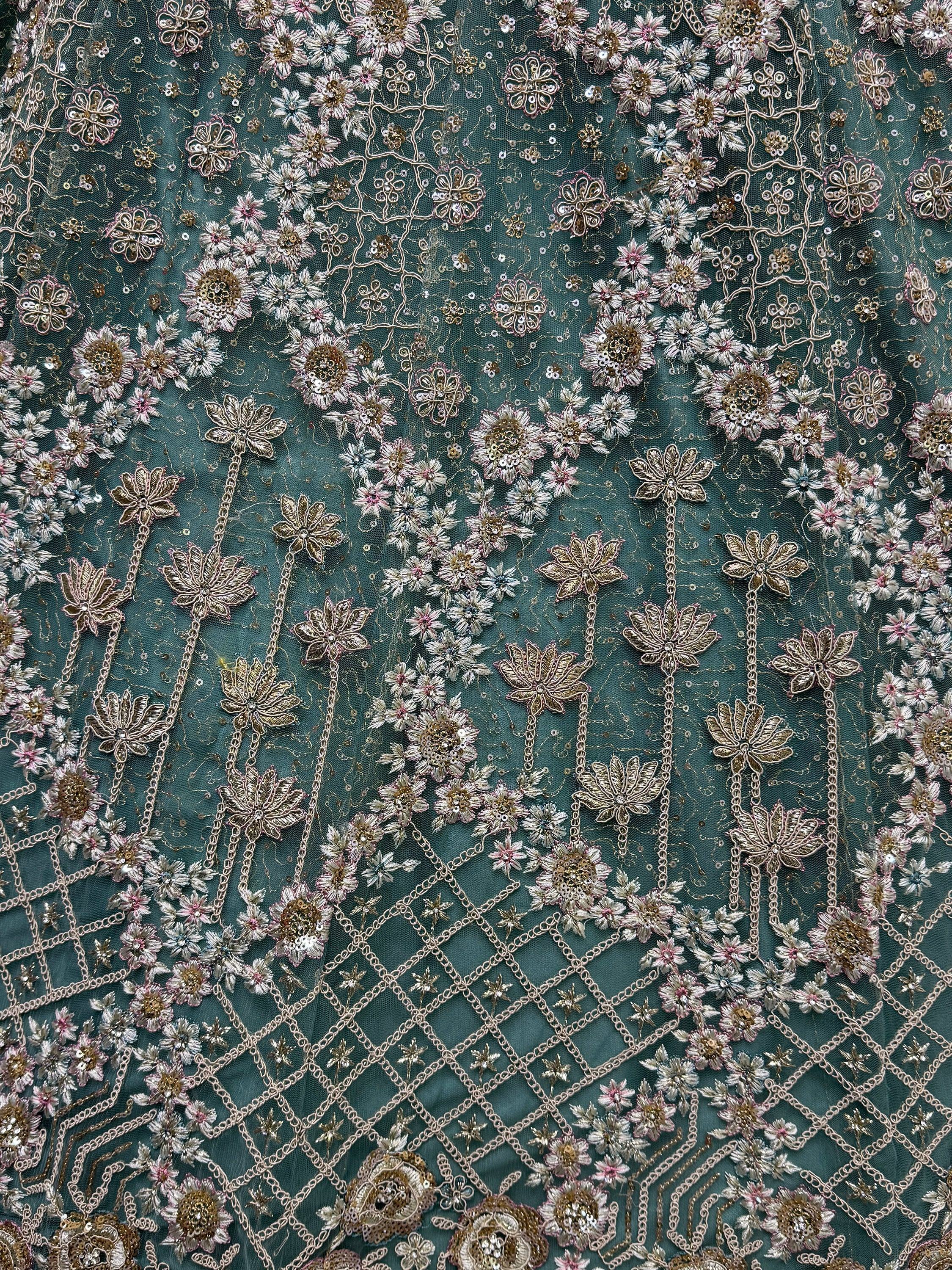 Teal ethnic fabric with floral embroidery, sequins, and gold chain detailing for designer lehenga or saree.