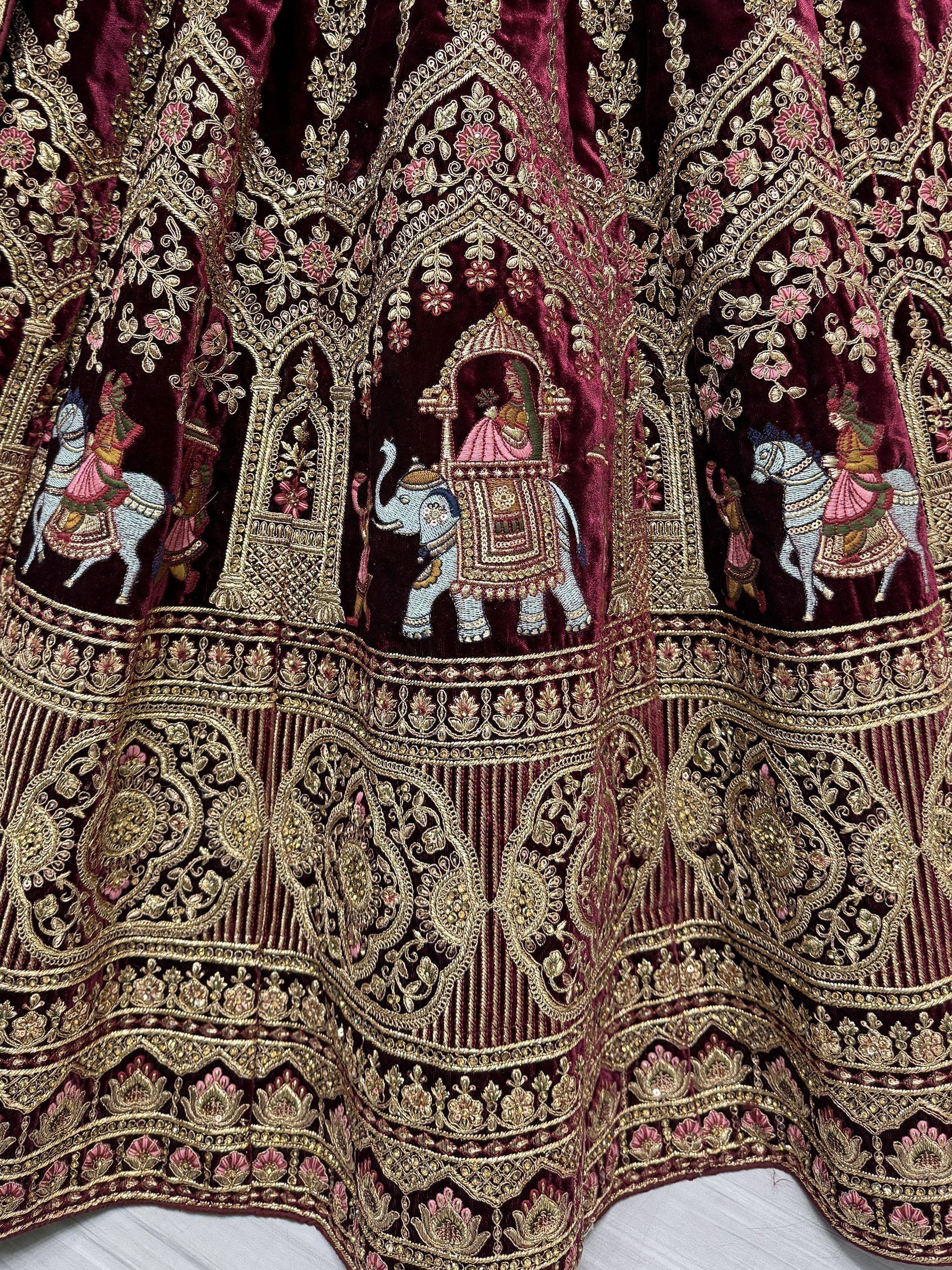 Richly embroidered maroon lehenga with golden floral and elephant motifs for Indian ethnic wear