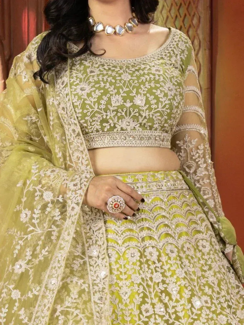 Elegant green lehenga choli with white floral embroidery, sheer sleeves, and matching dupatta for Indian ethnic wear.