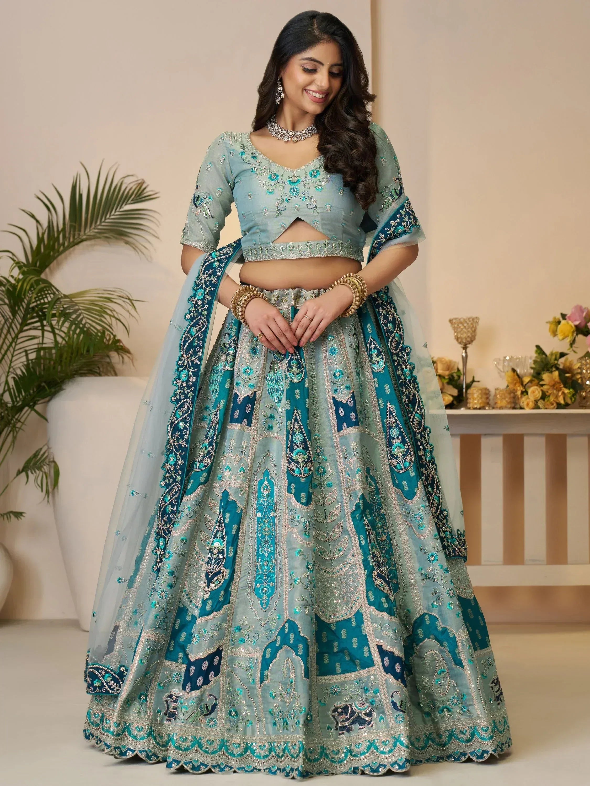 Teal and silver embroidered lehenga choli with floral motifs and dupatta, perfect for Indian weddings and festivals
