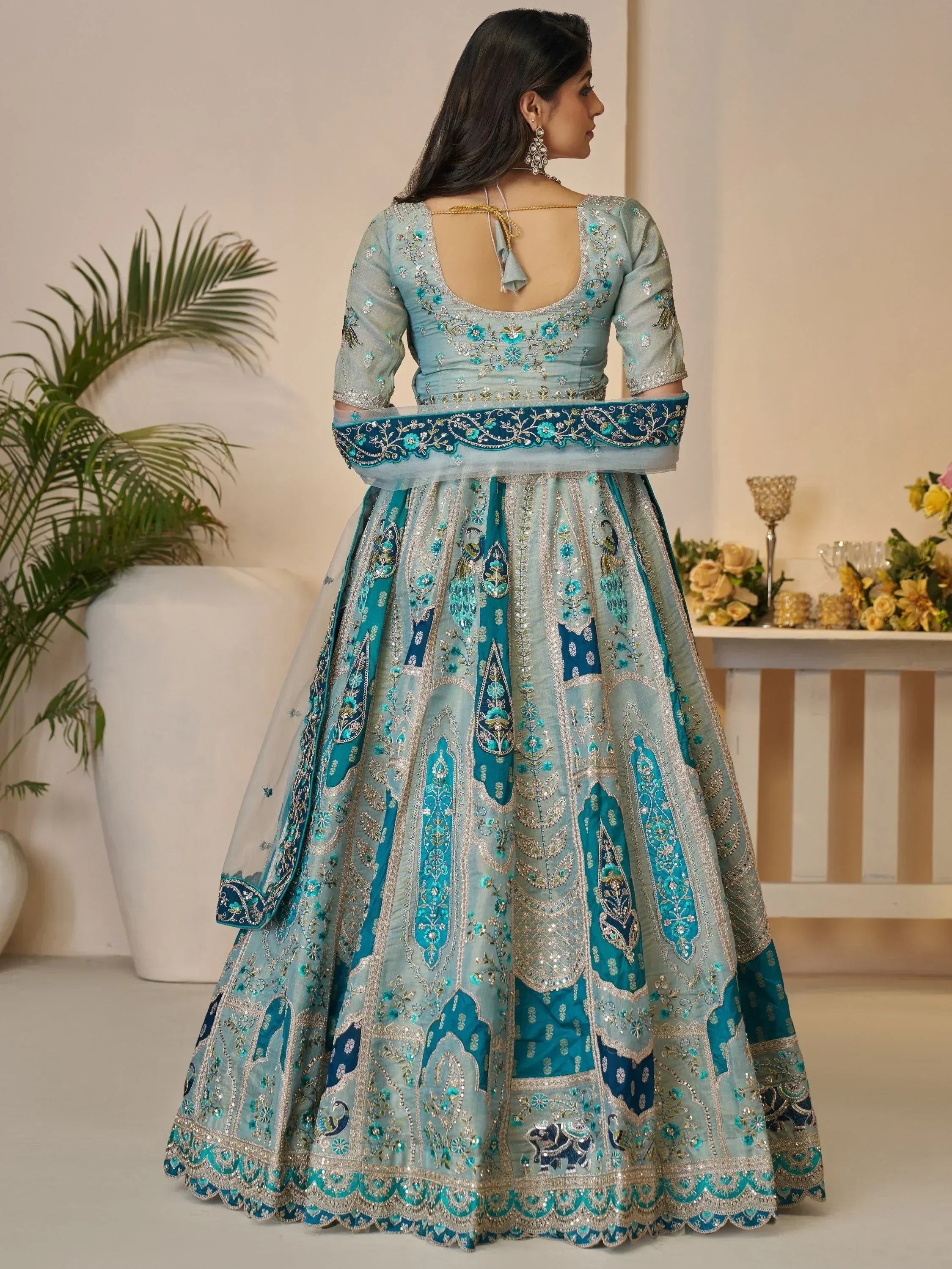 Elegant light blue designer lehenga choli with heavy floral and peacock embroidery, perfect for Indian weddings.