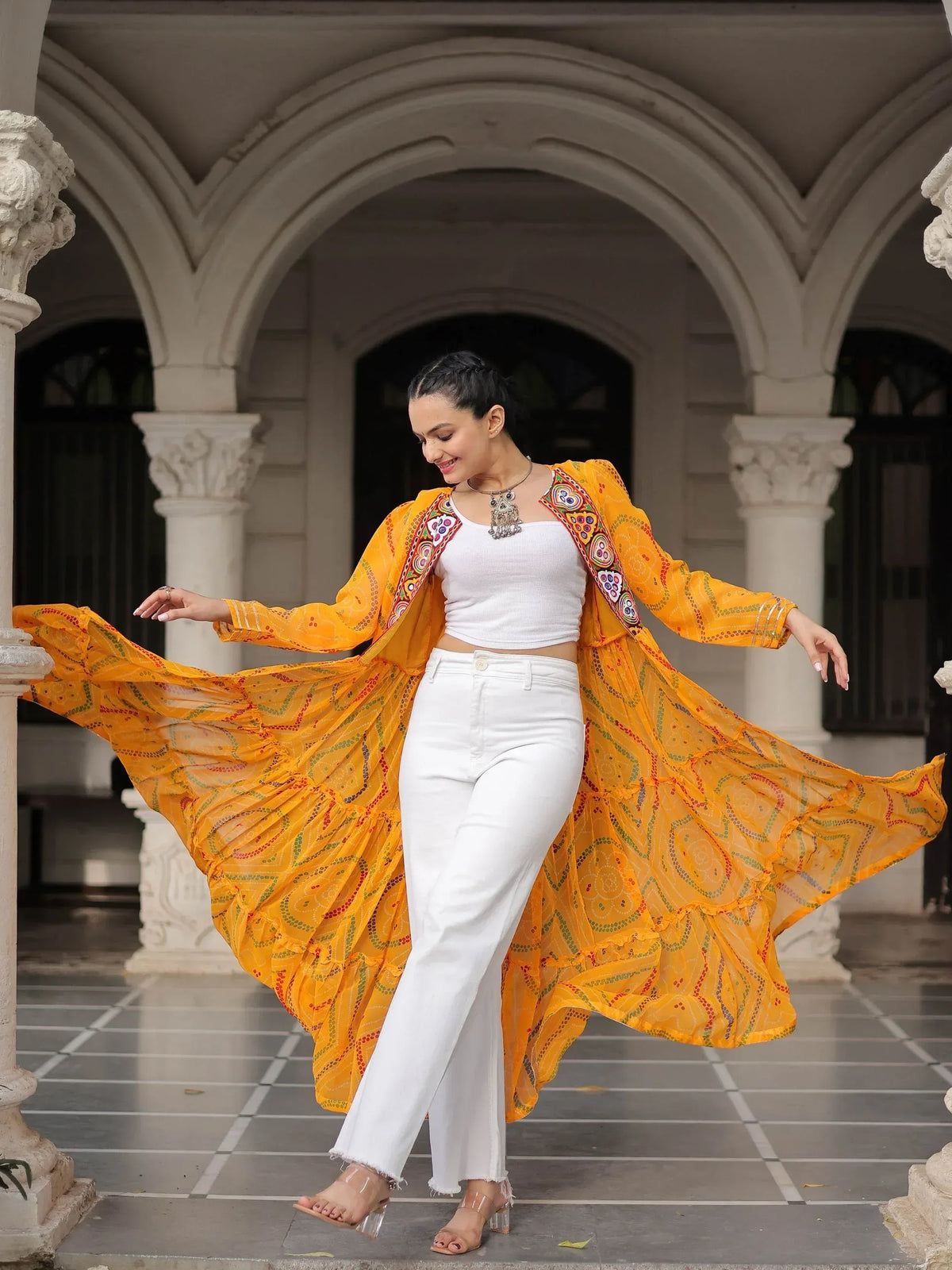 Woman in vibrant yellow embroidered ethnic jacket with white top and pants, dancing under arched colonnade