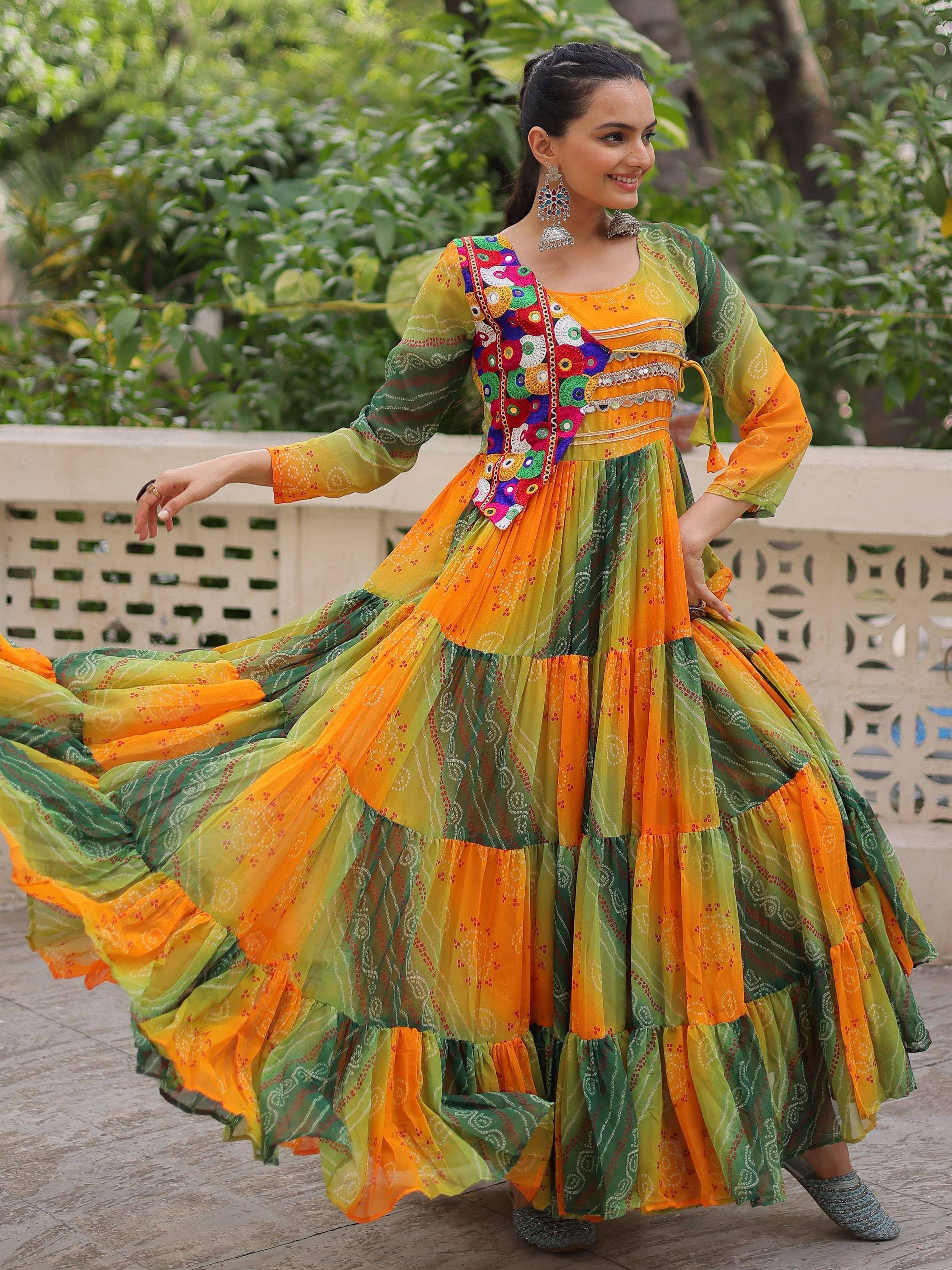 Vibrant orange and green tiered ethnic gown with mirror work, perfect for festive occasions