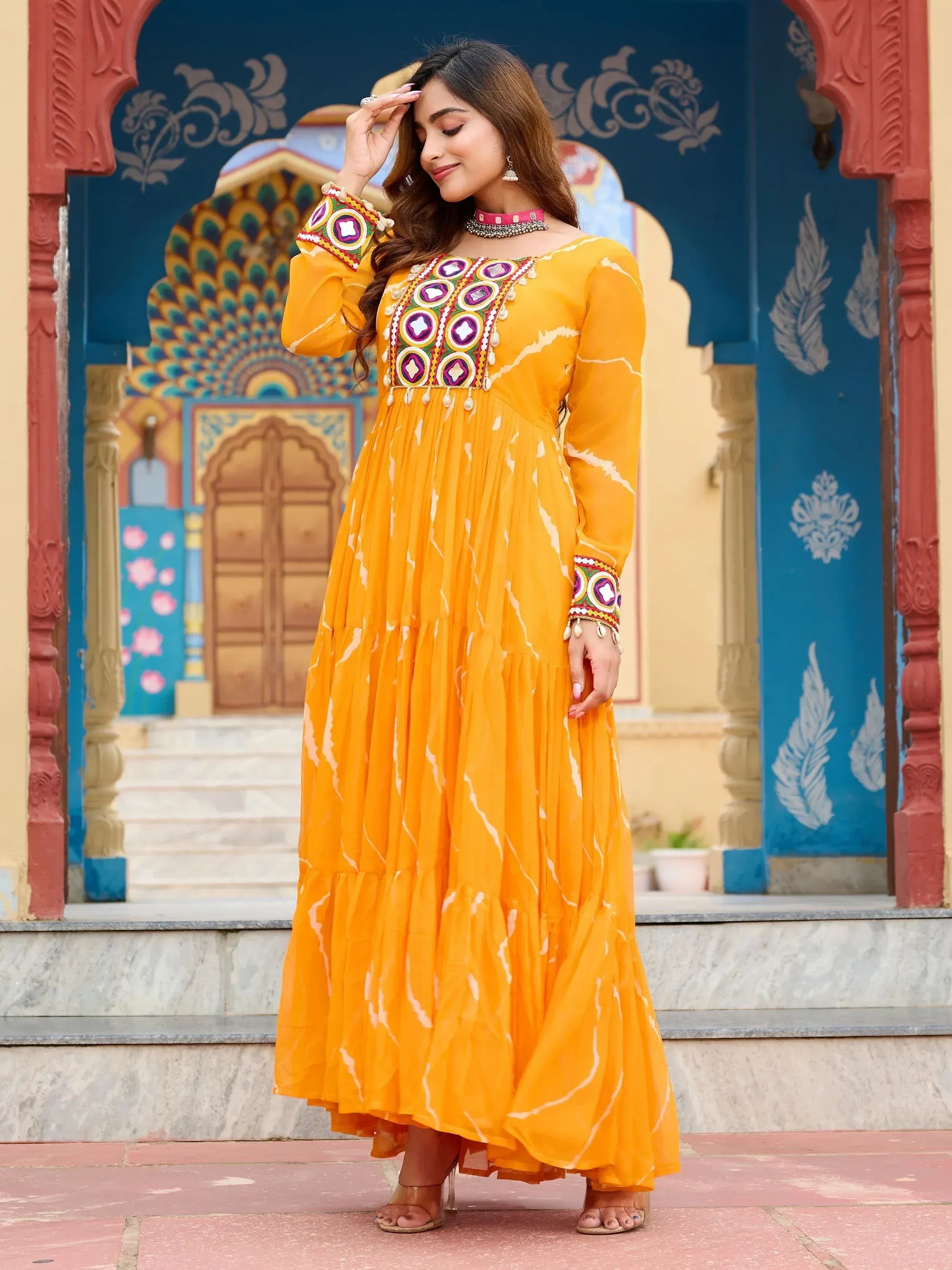 Yellow ethnic gown with mirror work and tie-dye print, perfect for Indian occasions