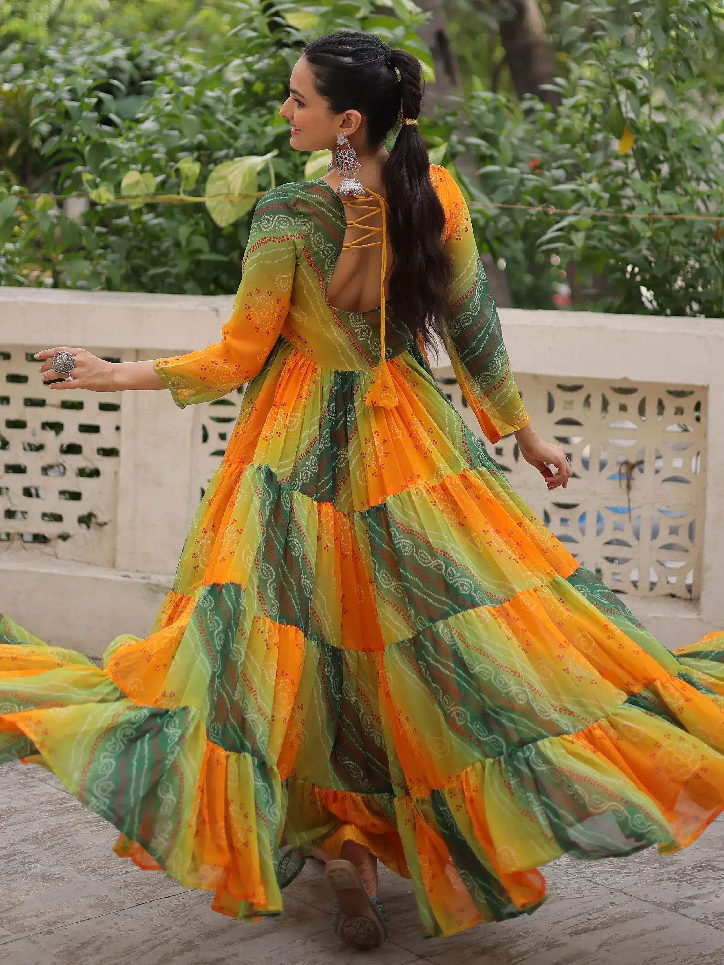 Vibrant orange and green printed ethnic gown with back tie detail, perfect for festive occasions