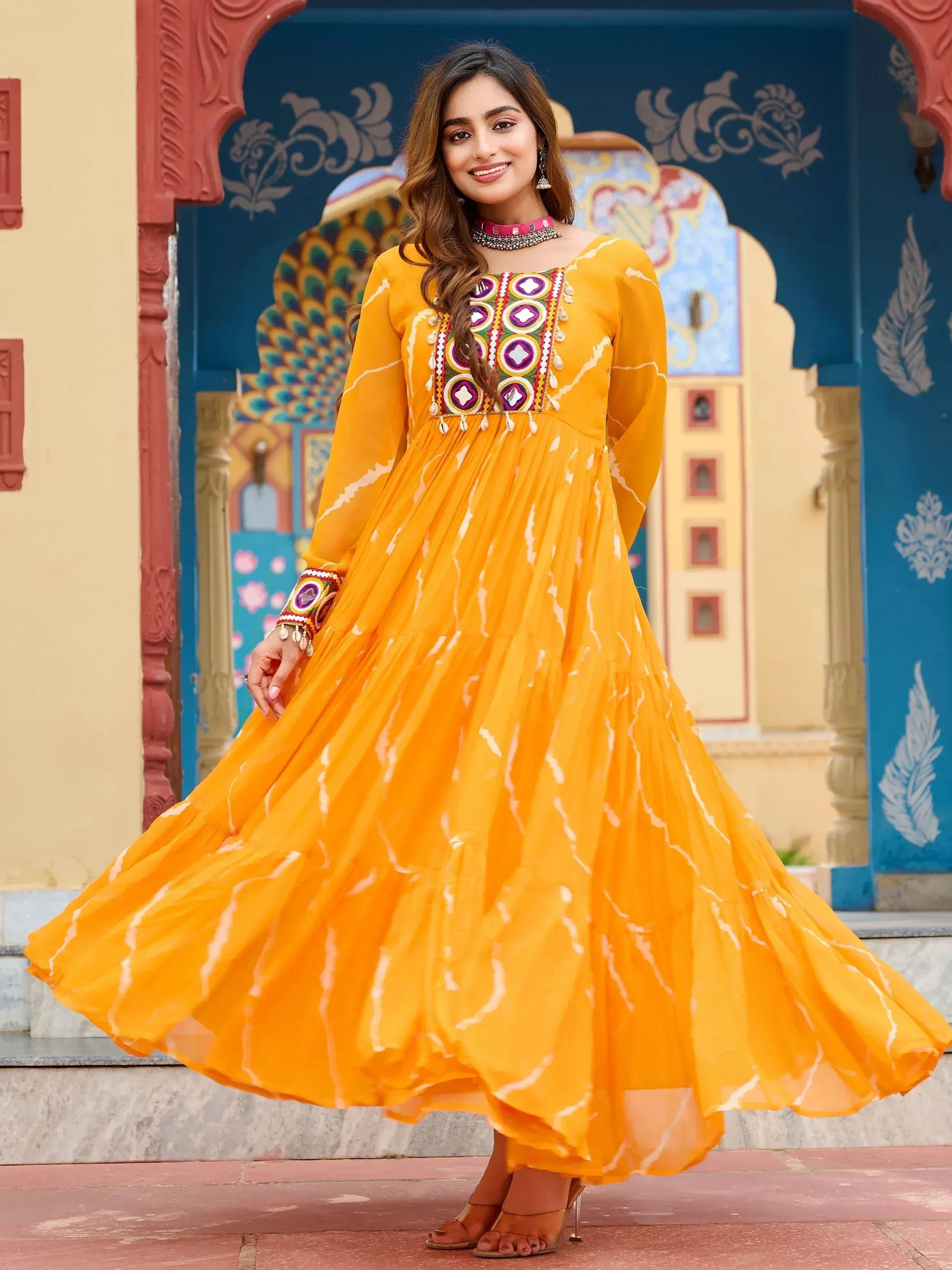 Vibrant yellow ethnic gown with mirror work, perfect for Indian festive occasions and celebrations.
