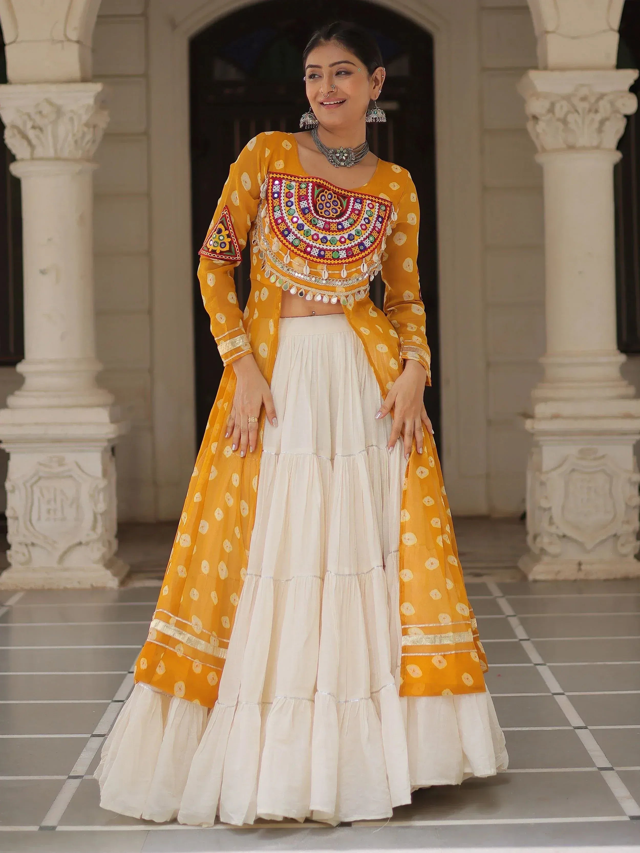 Yellow and white embroidered lehenga choli with mirror work, perfect for Indian ethnic wear events