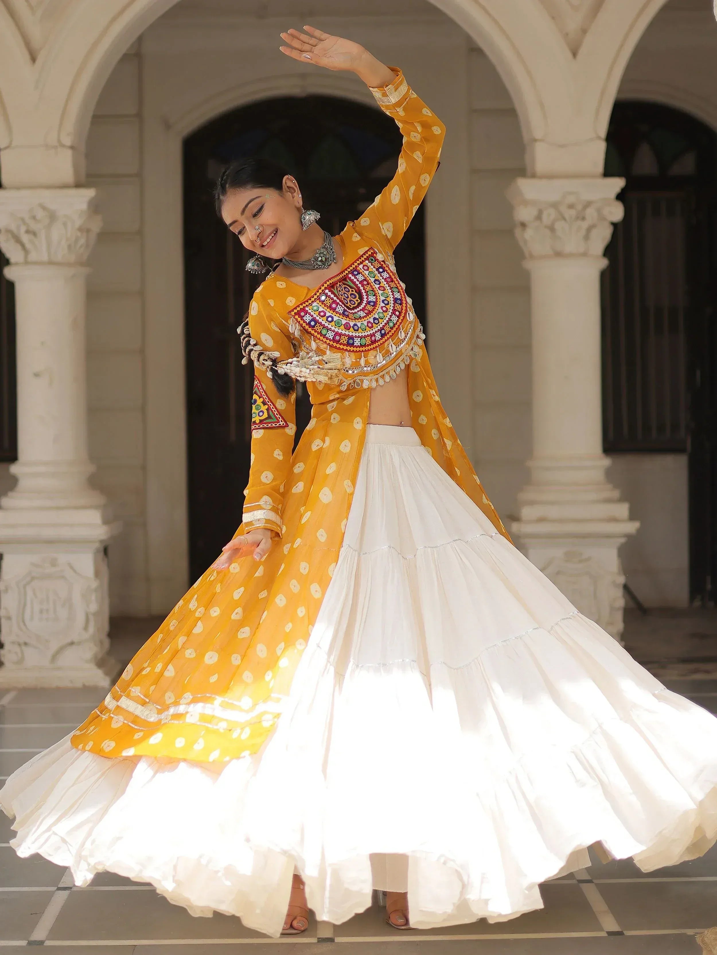 Yellow and white embroidered lehenga choli with mirror work, perfect for Indian ethnic wear and festive occasions.