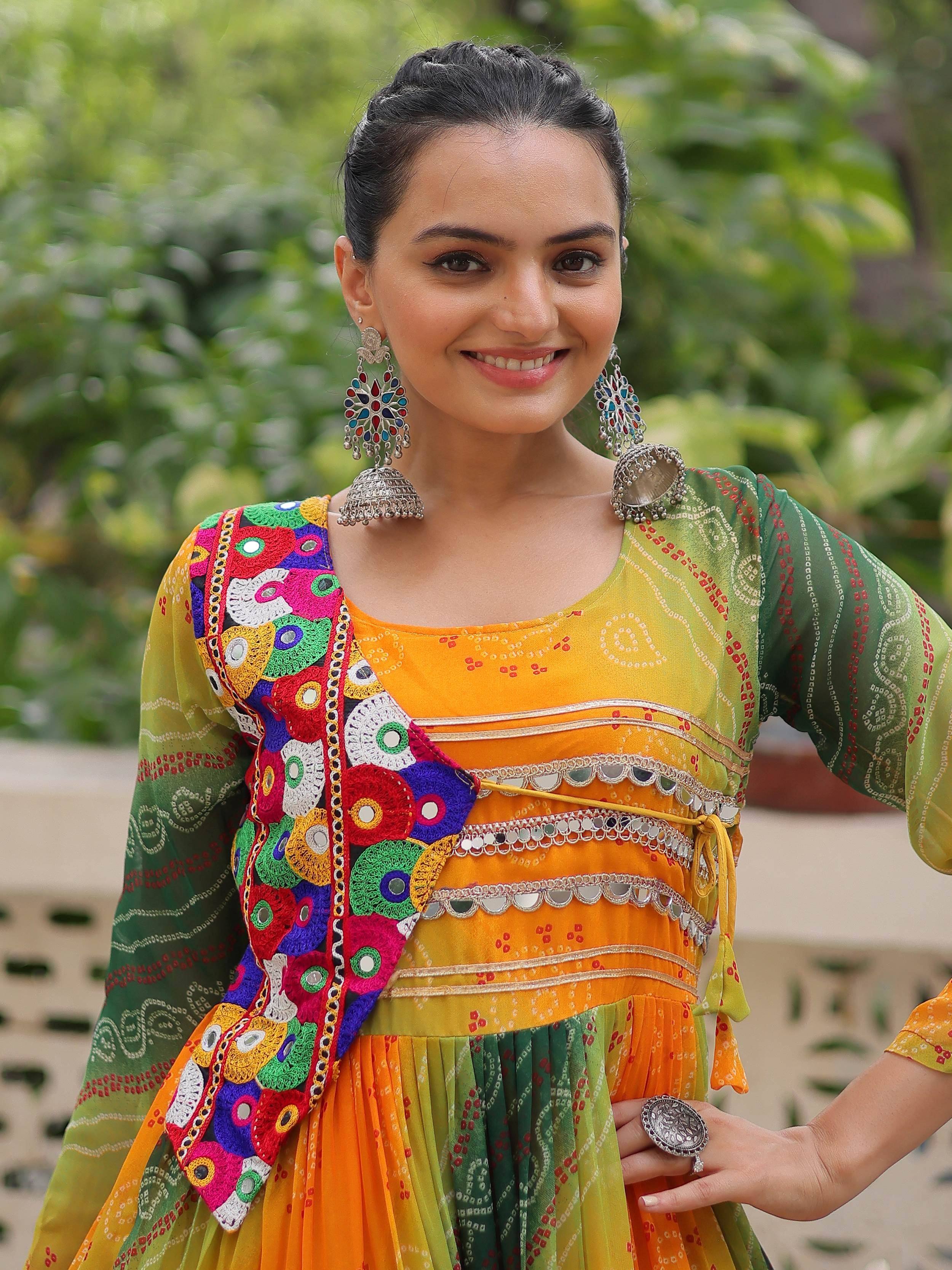 Woman in vibrant Indian ethnic wear with mirror work, colorful embroidery, and traditional jhumka earrings.