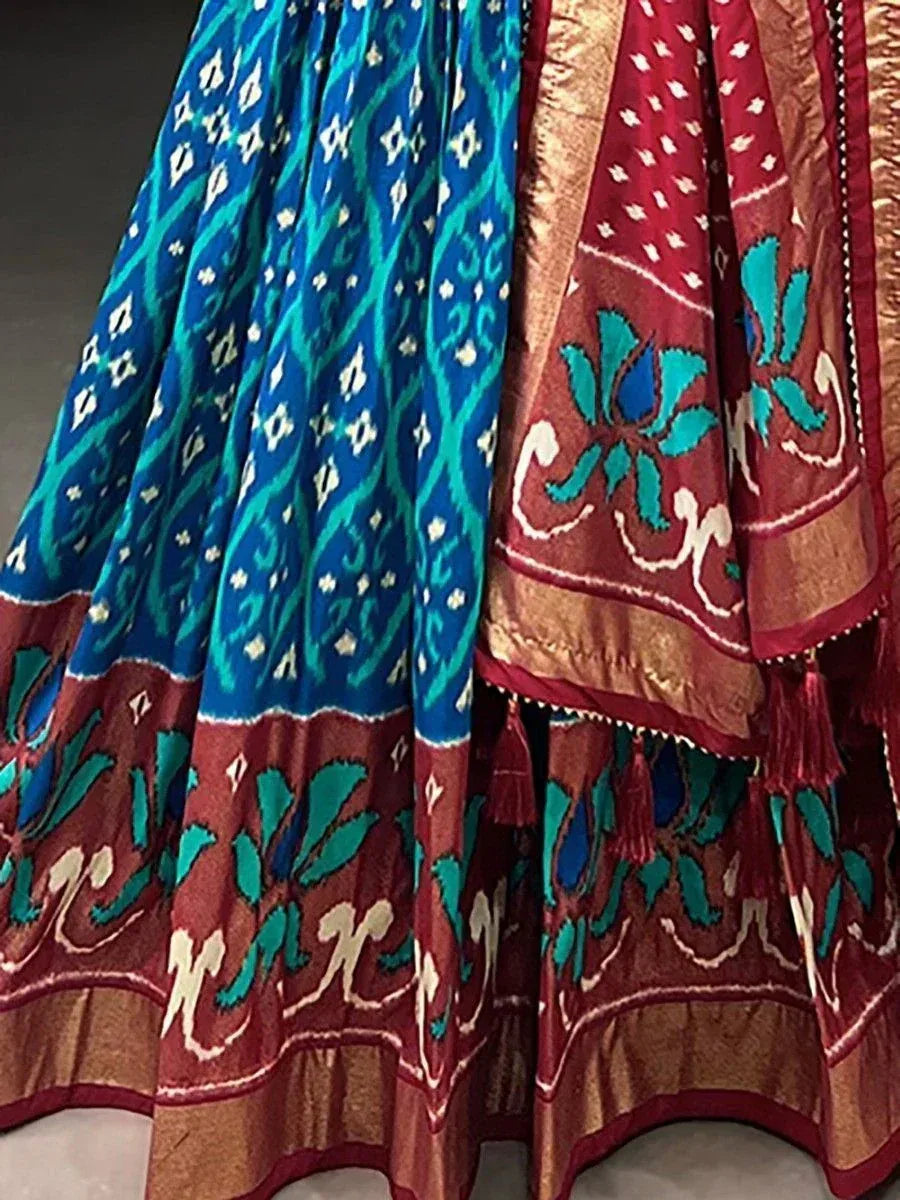 Blue and red ikat print lehenga choli with floral motifs and gold border, ethnic Indian wear
