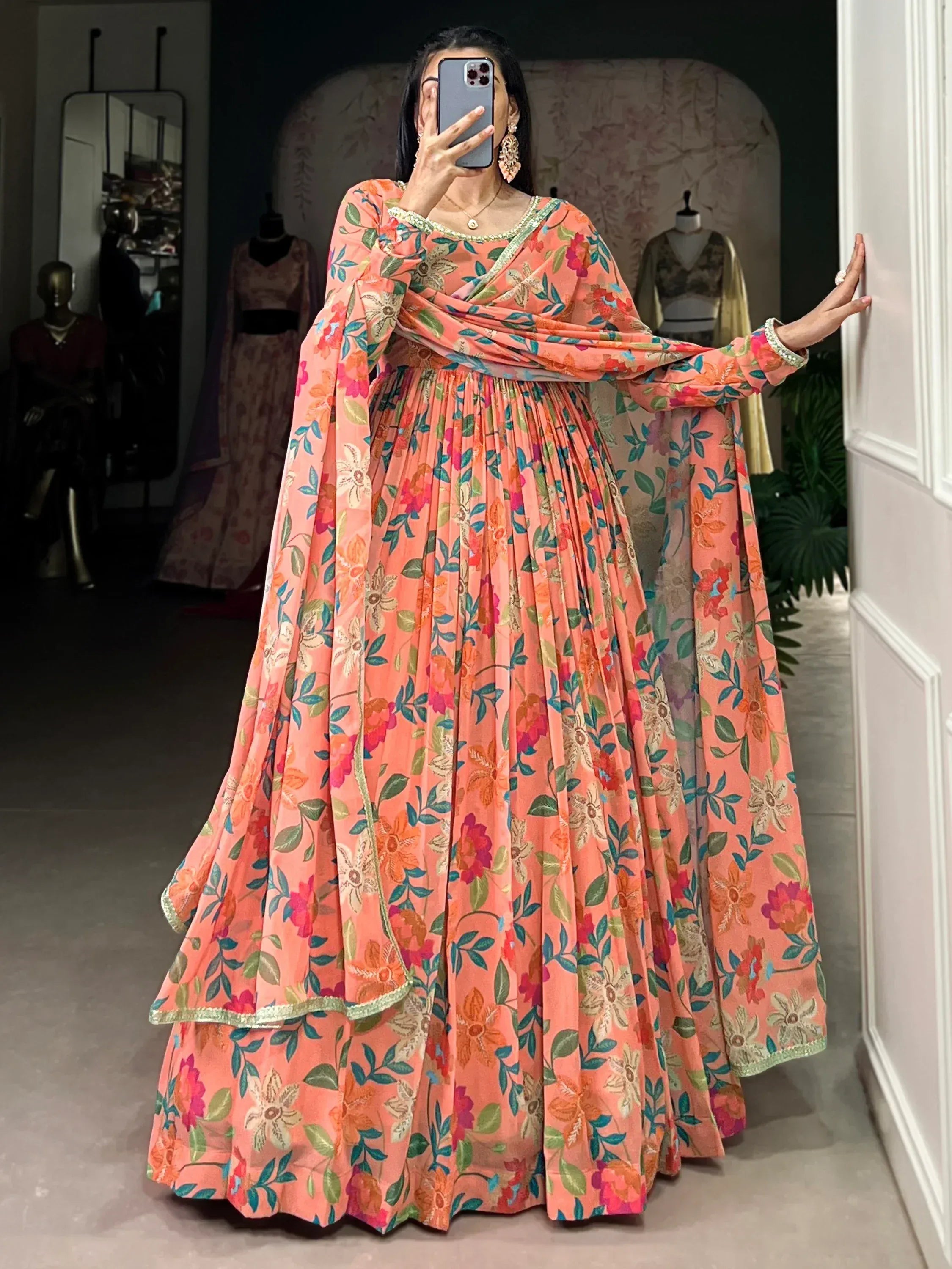 Peach floral print Indian ethnic gown with pleated skirt and long sleeves, perfect for festive occasions.