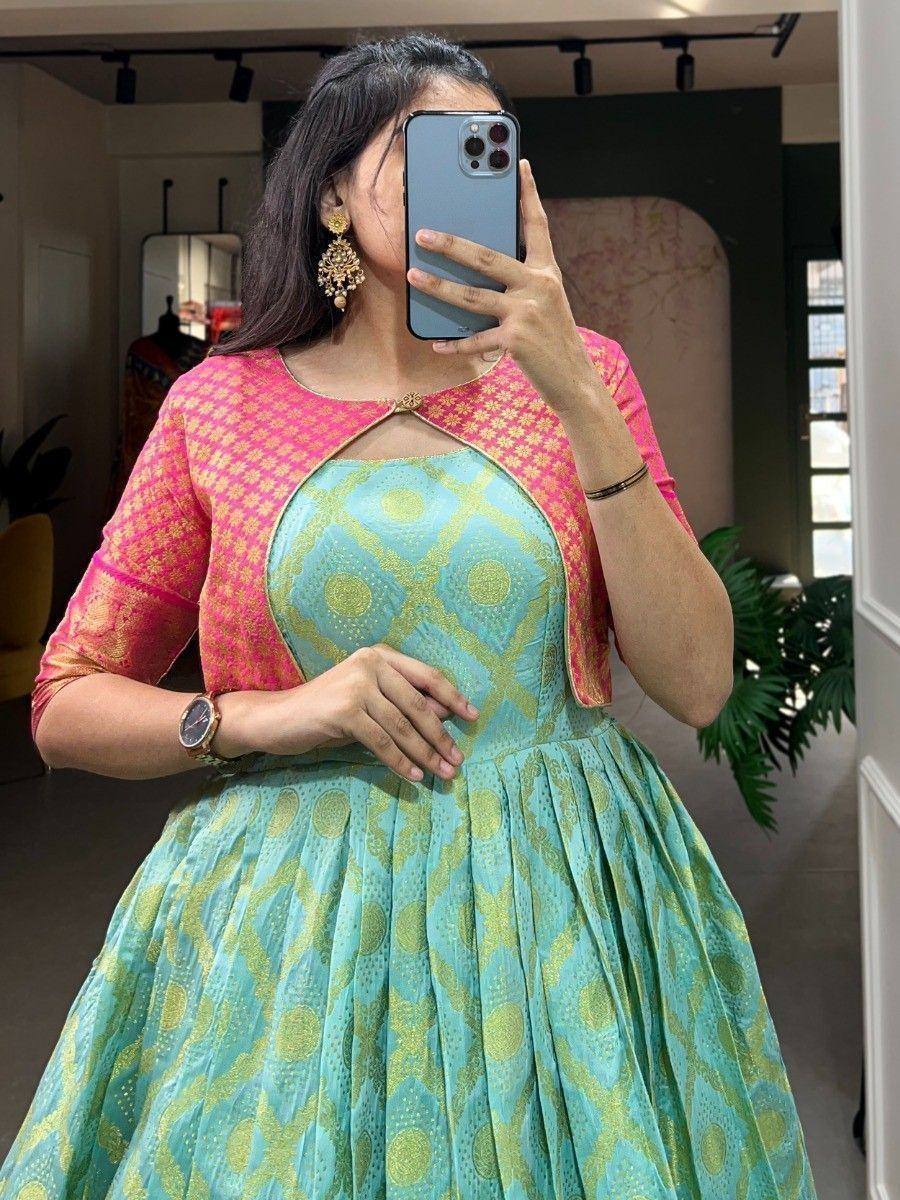 Woman in turquoise and pink ethnic gown with gold print, mirror selfie, designer Indian wear