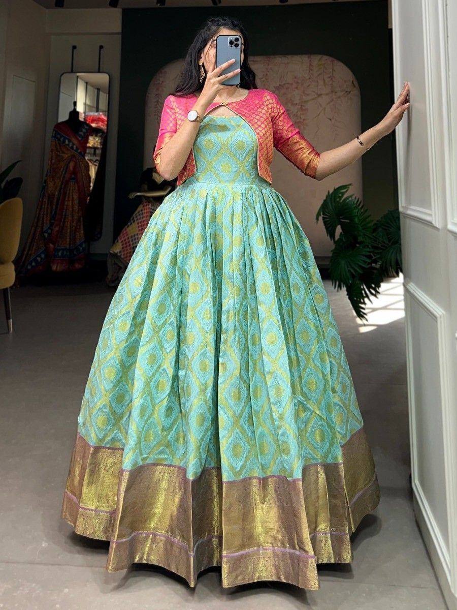 Turquoise ethnic gown with gold border and pink jacket, perfect for Indian weddings or festive occasions