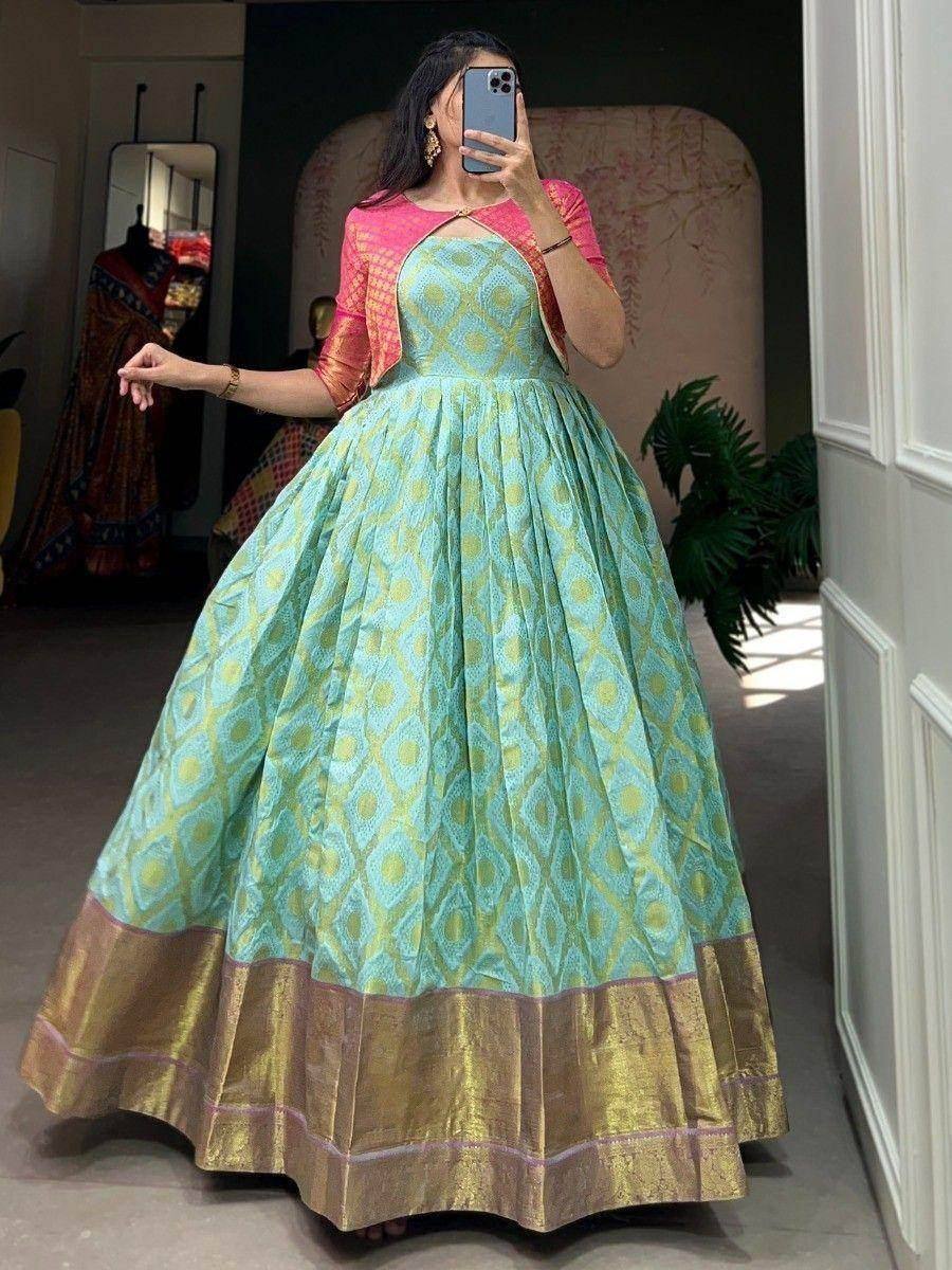 Turquoise ethnic gown with gold border and pink cape, perfect for Indian occasions