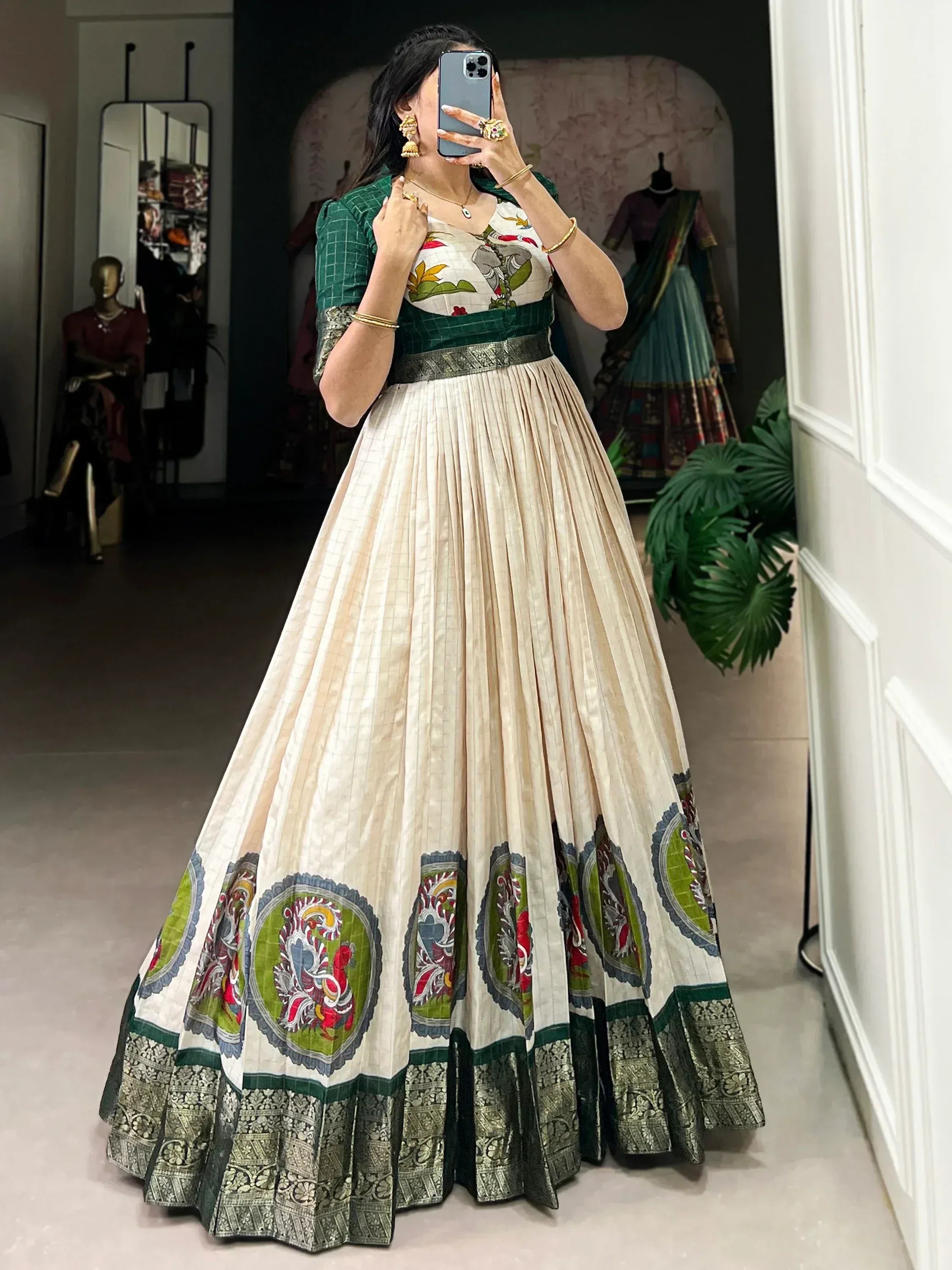 Woman wearing cream and green embroidered Indian ethnic gown with floral motifs