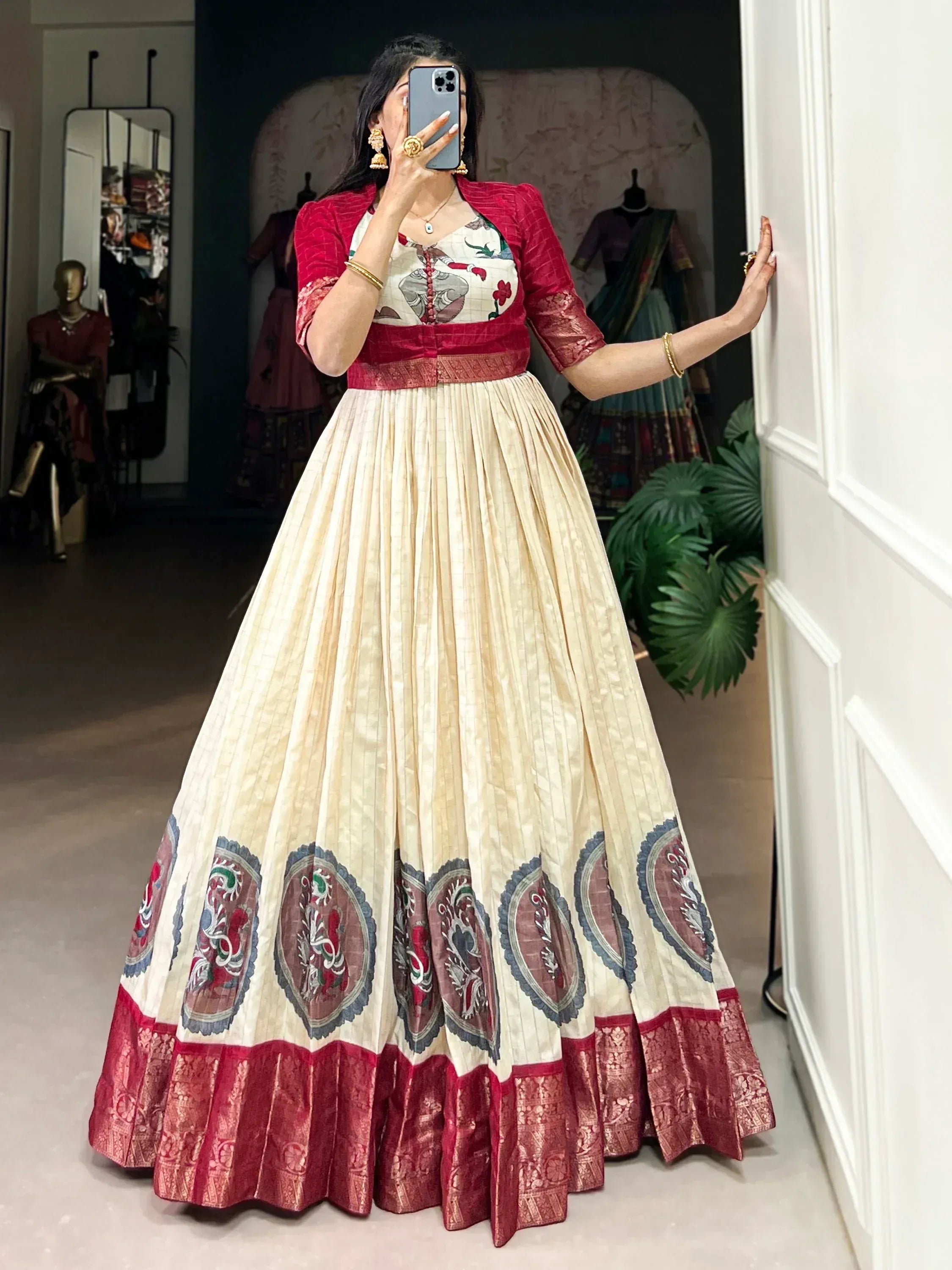 Woman in cream and red embroidered lehenga choli with floral motifs, perfect for Indian ethnic wear occasions.