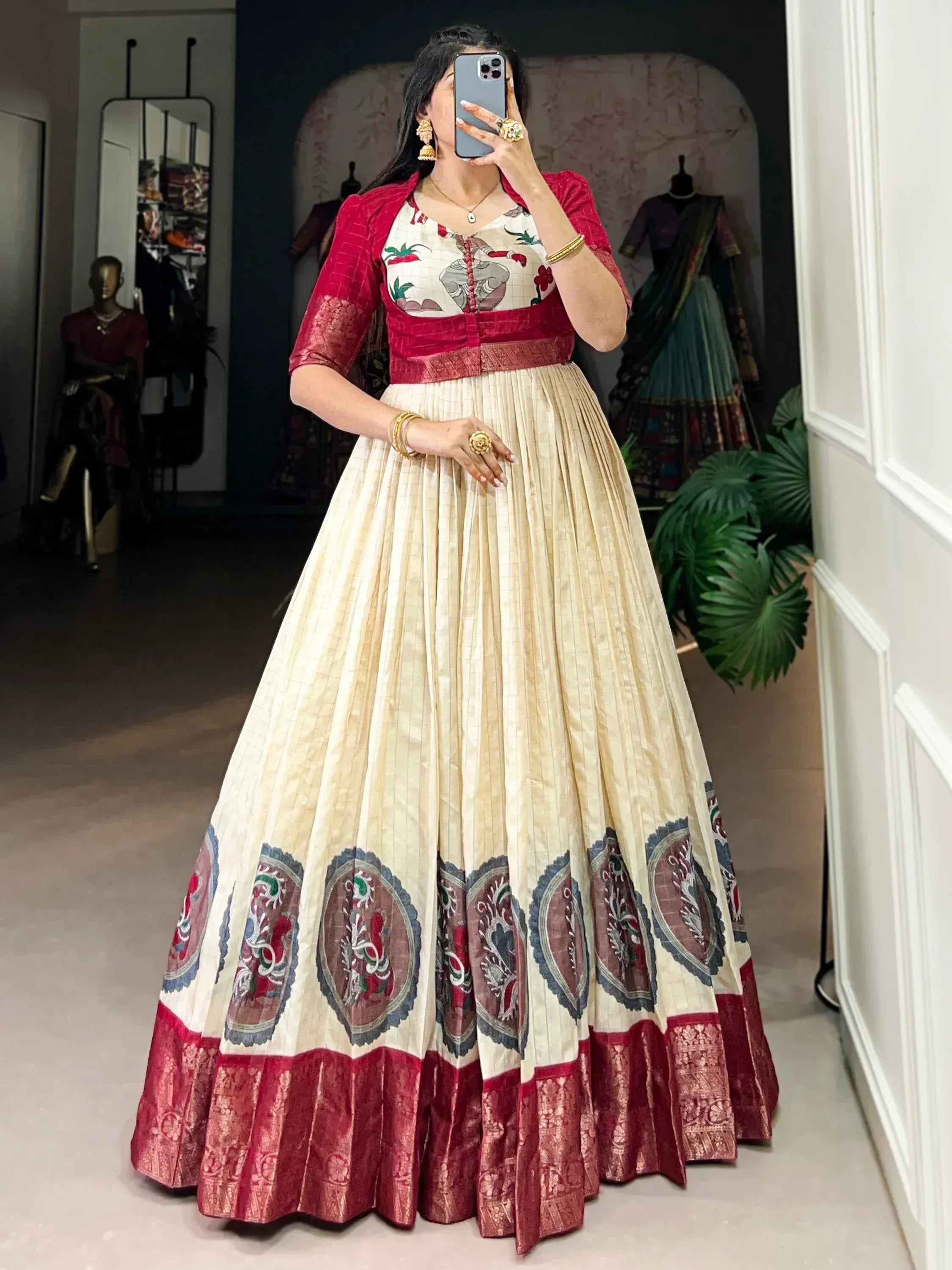 Elegant cream and red lehenga choli with floral embroidery and pleated skirt, perfect for Indian ethnic wear occasions.