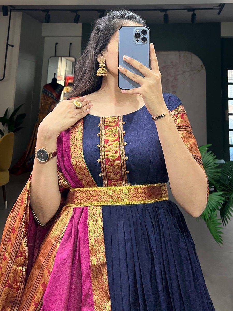 Woman in navy blue ethnic gown with gold embroidery and pink dupatta, perfect for Indian occasions