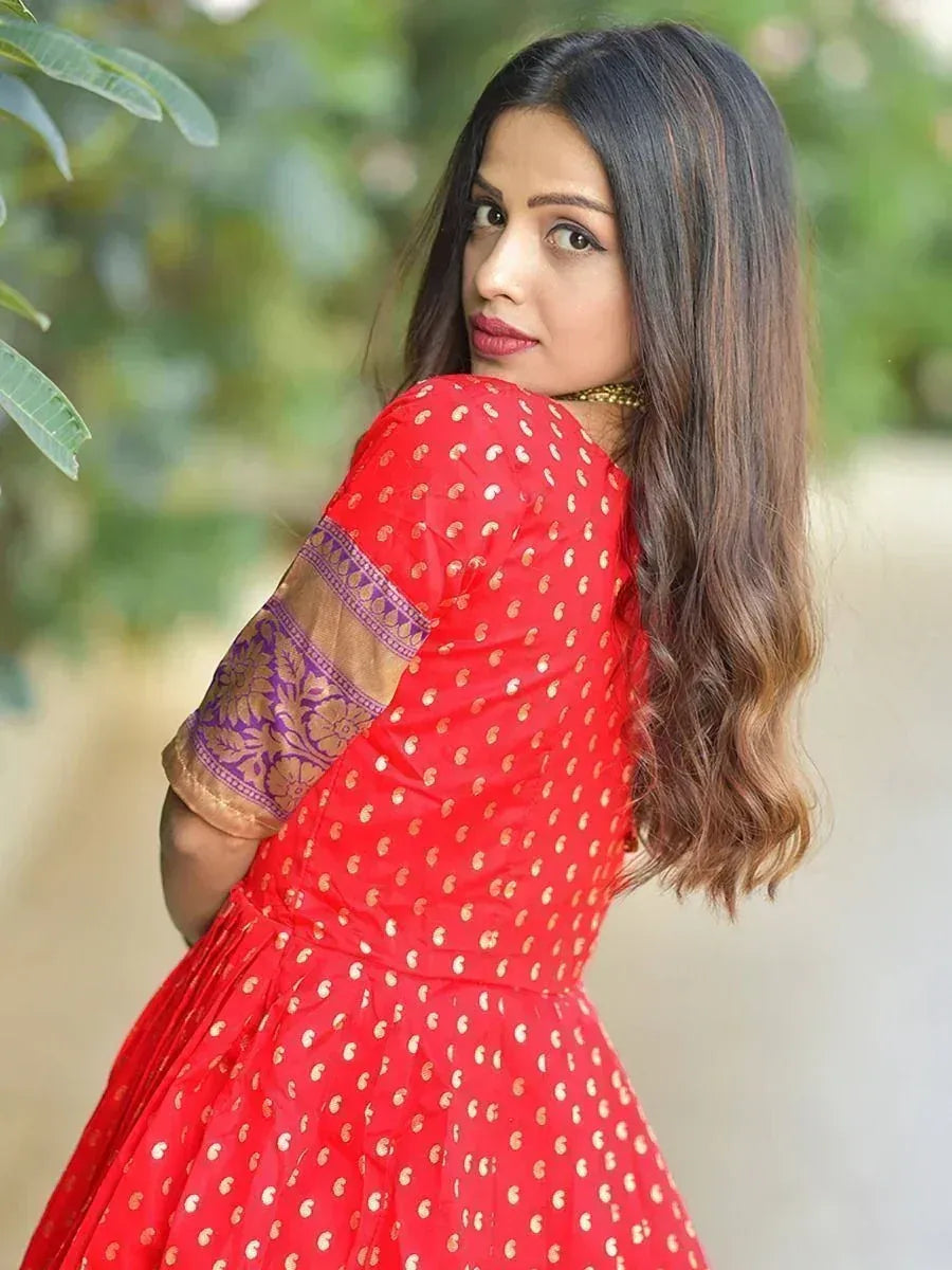 Woman in red Indian ethnic dress with gold polka dots and purple embroidered sleeves