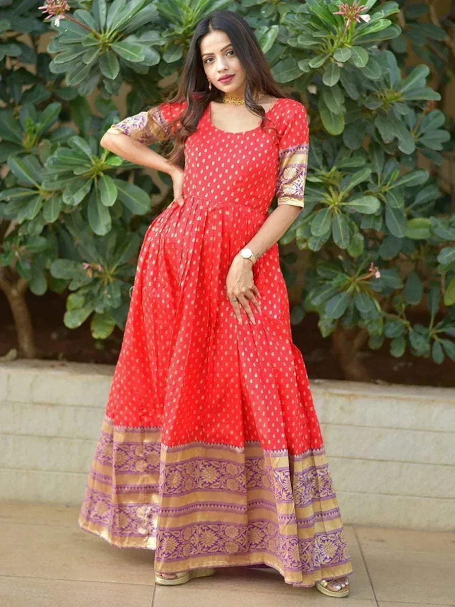 Woman wearing red ethnic gown with gold and purple border, posing outdoors