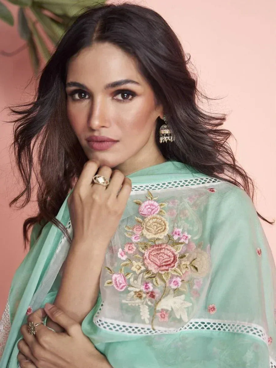 Woman in mint green embroidered ethnic saree with floral design, perfect for Indian occasions