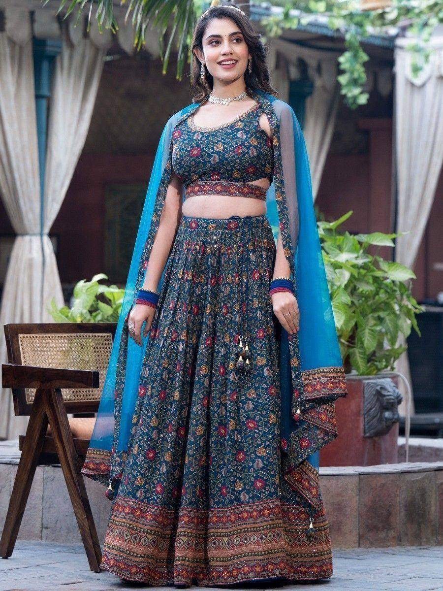 Woman in floral printed lehenga choli with blue dupatta, ethnic Indian wear for festive occasions