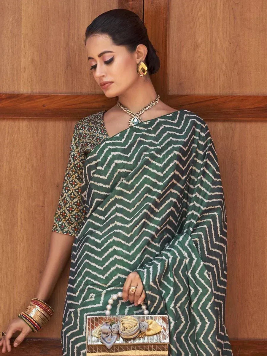 Green zigzag pattern saree with embroidered blouse, ethnic jewelry, and pearl clutch for Indian occasions