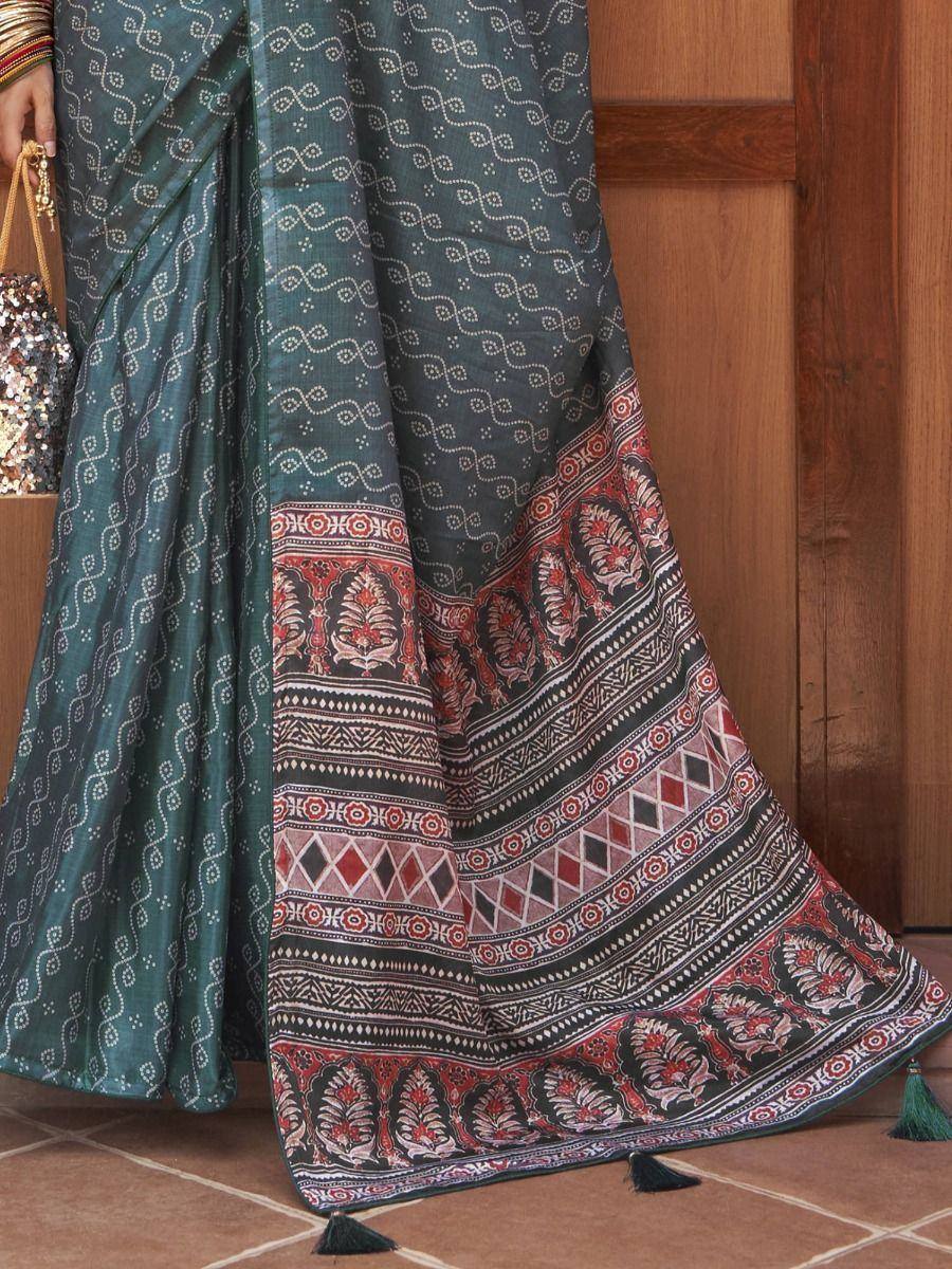 Teal saree with white swirl print and red-black border, ethnic Indian wear with tassels