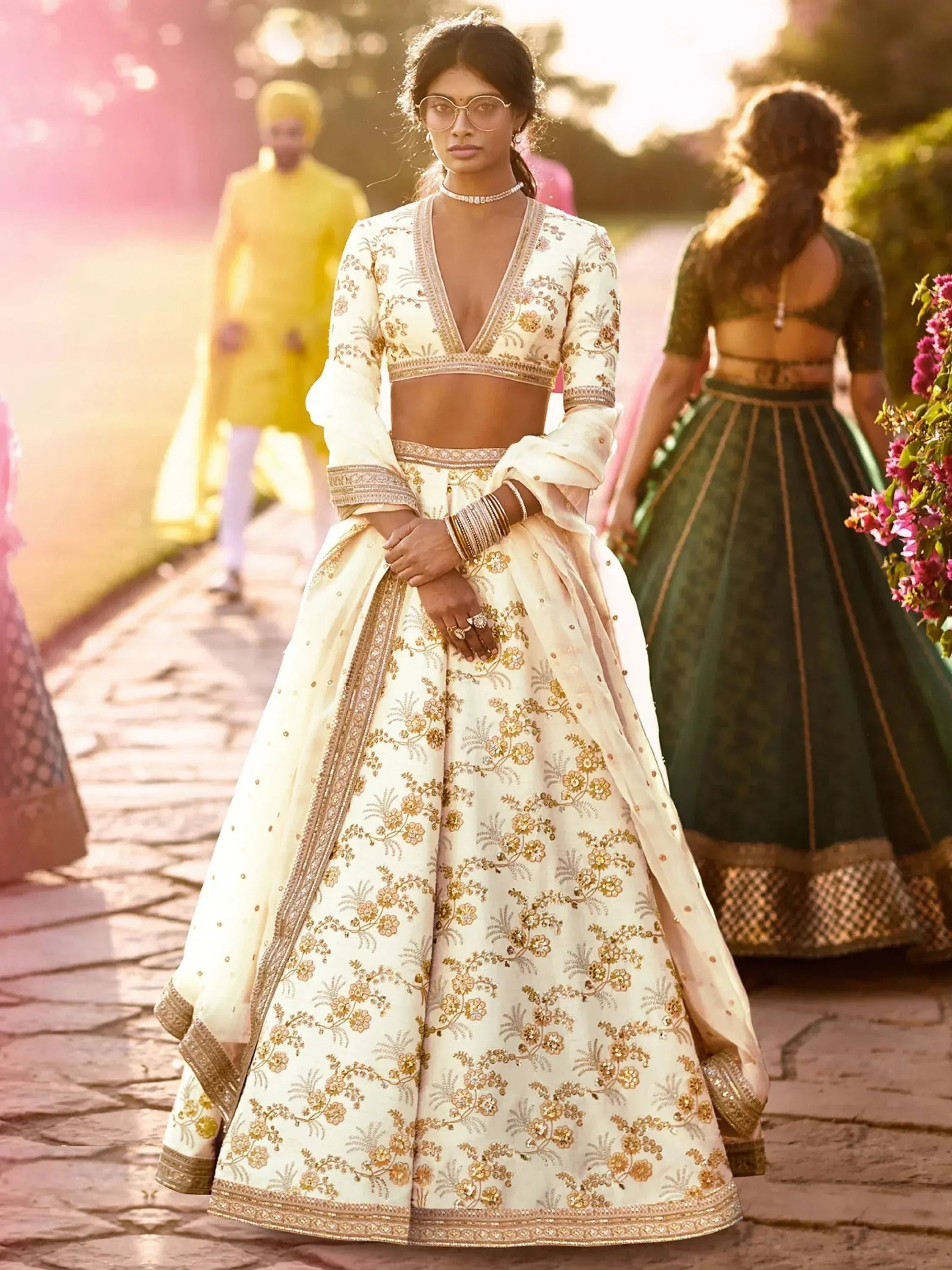 Elegant cream lehenga choli with gold floral embroidery, perfect for Indian weddings and festive occasions.