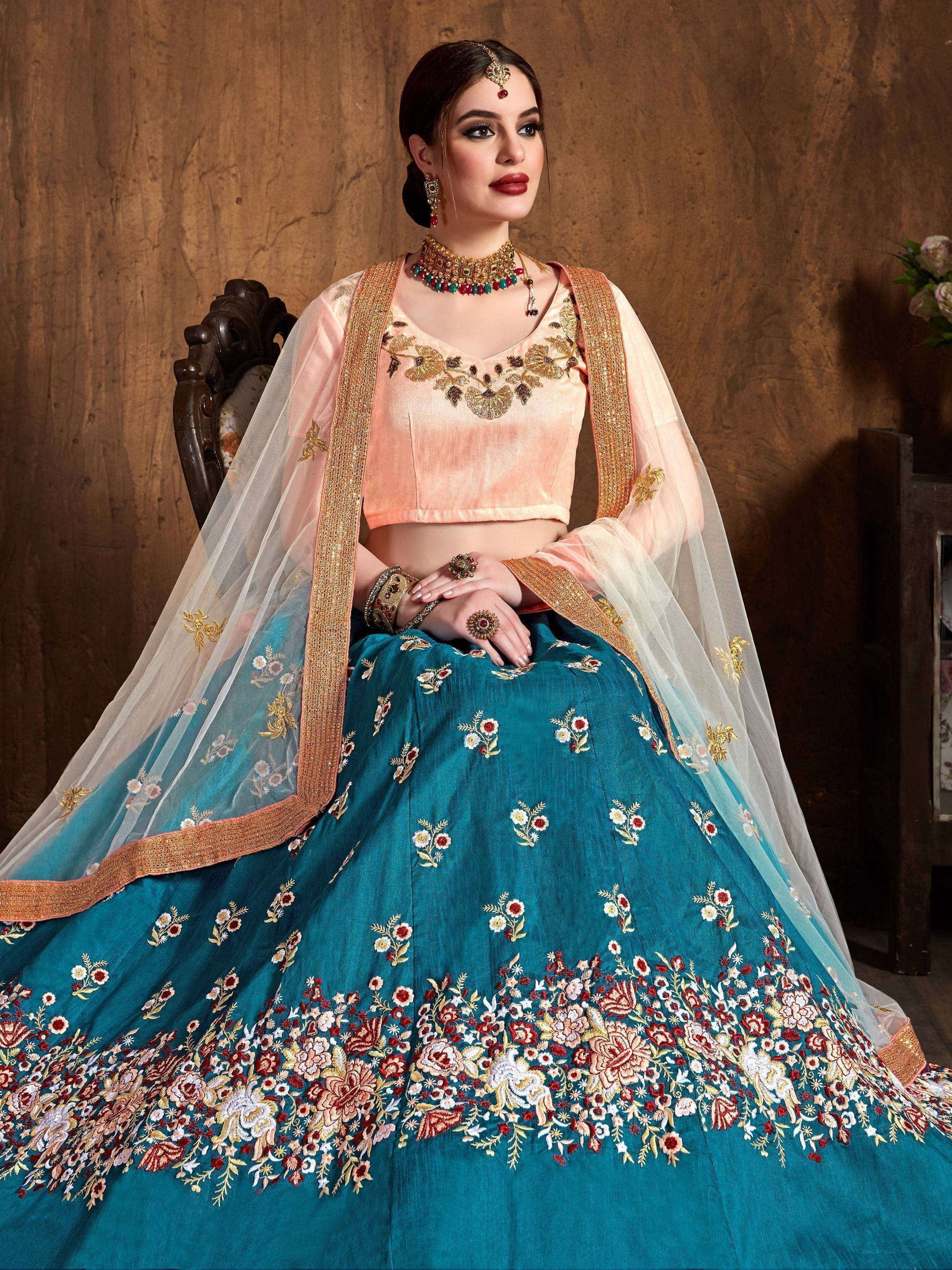 Teal and peach embroidered lehenga choli with floral motifs, perfect for Indian weddings and festive occasions.