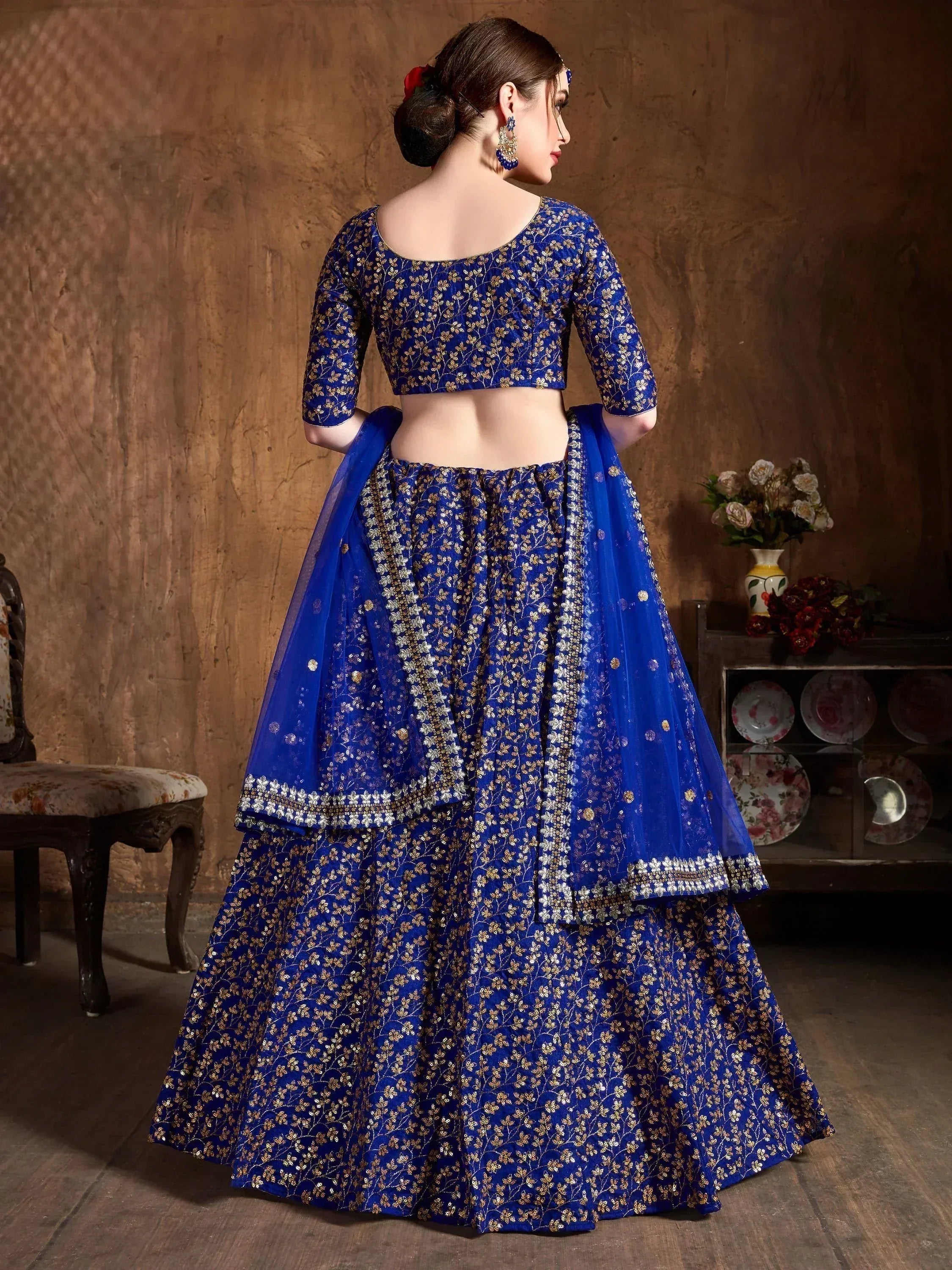Royal blue embroidered lehenga choli with gold floral work, perfect for Indian weddings and festive occasions.
