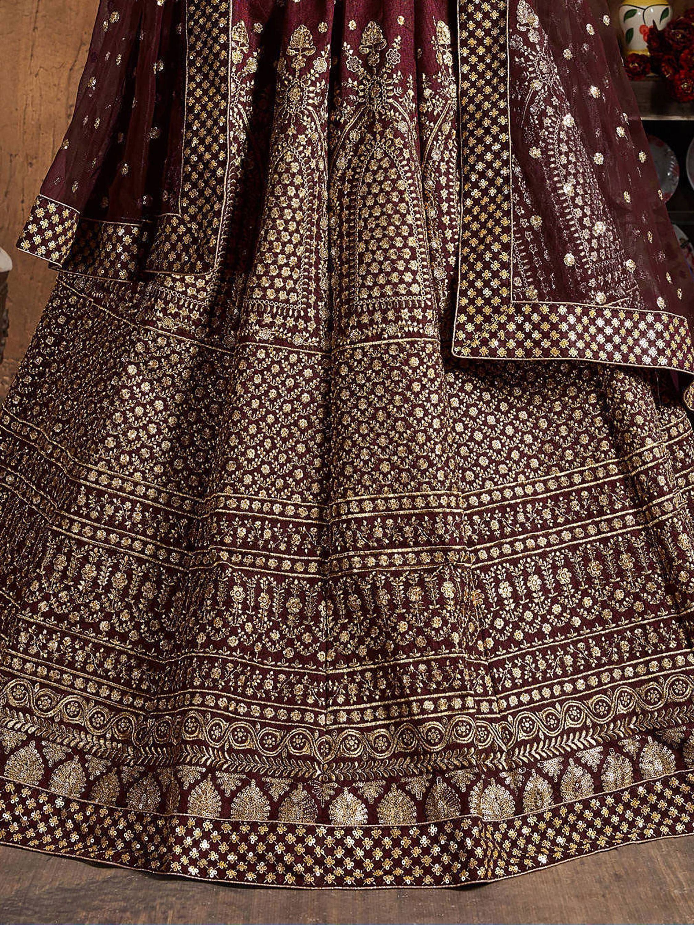 Maroon ethnic lehenga choli with intricate gold floral embroidery and sequin detailing, perfect for Indian weddings.