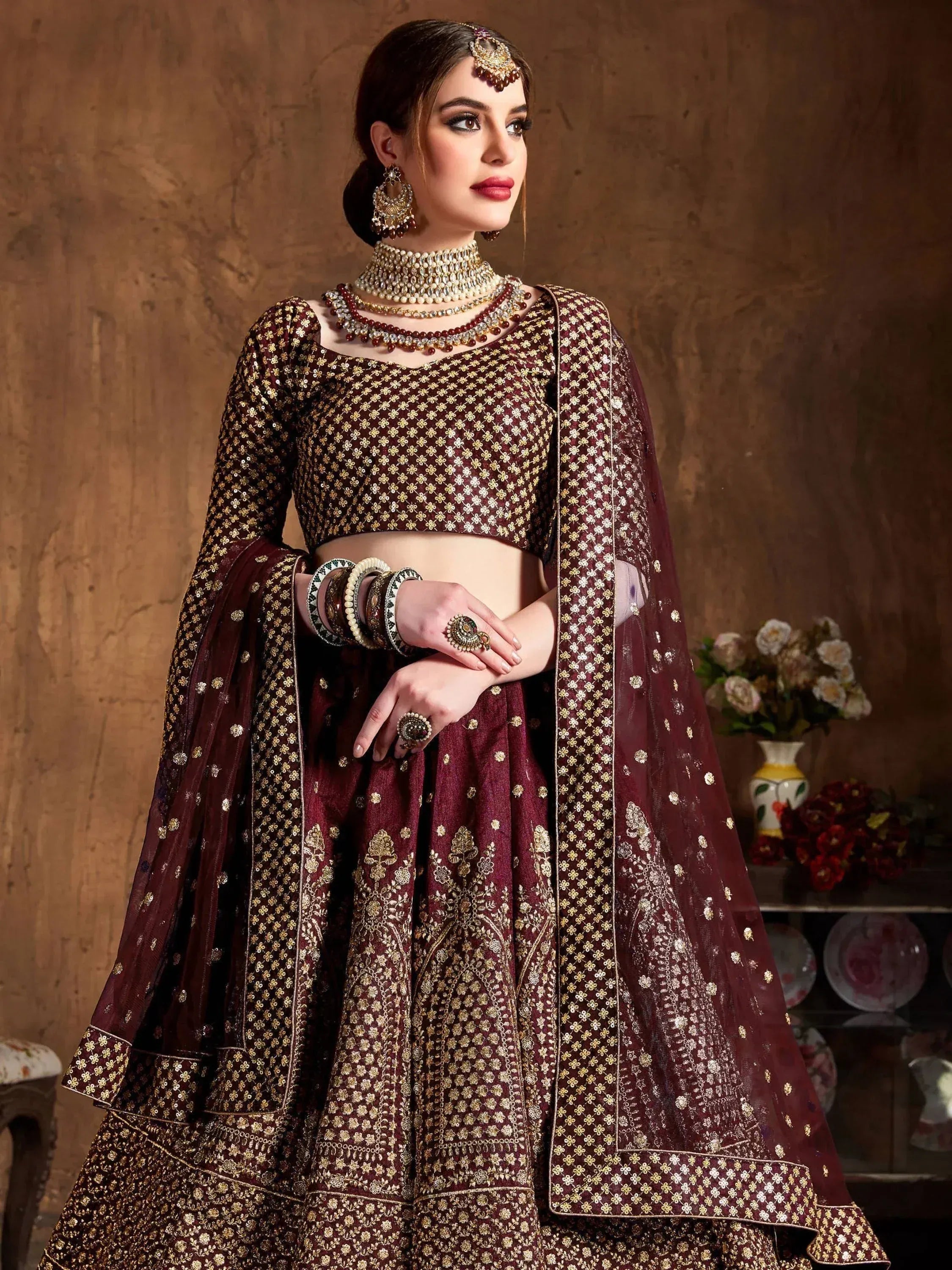 Maroon designer lehenga choli with gold embroidery, perfect for weddings and festive occasions.