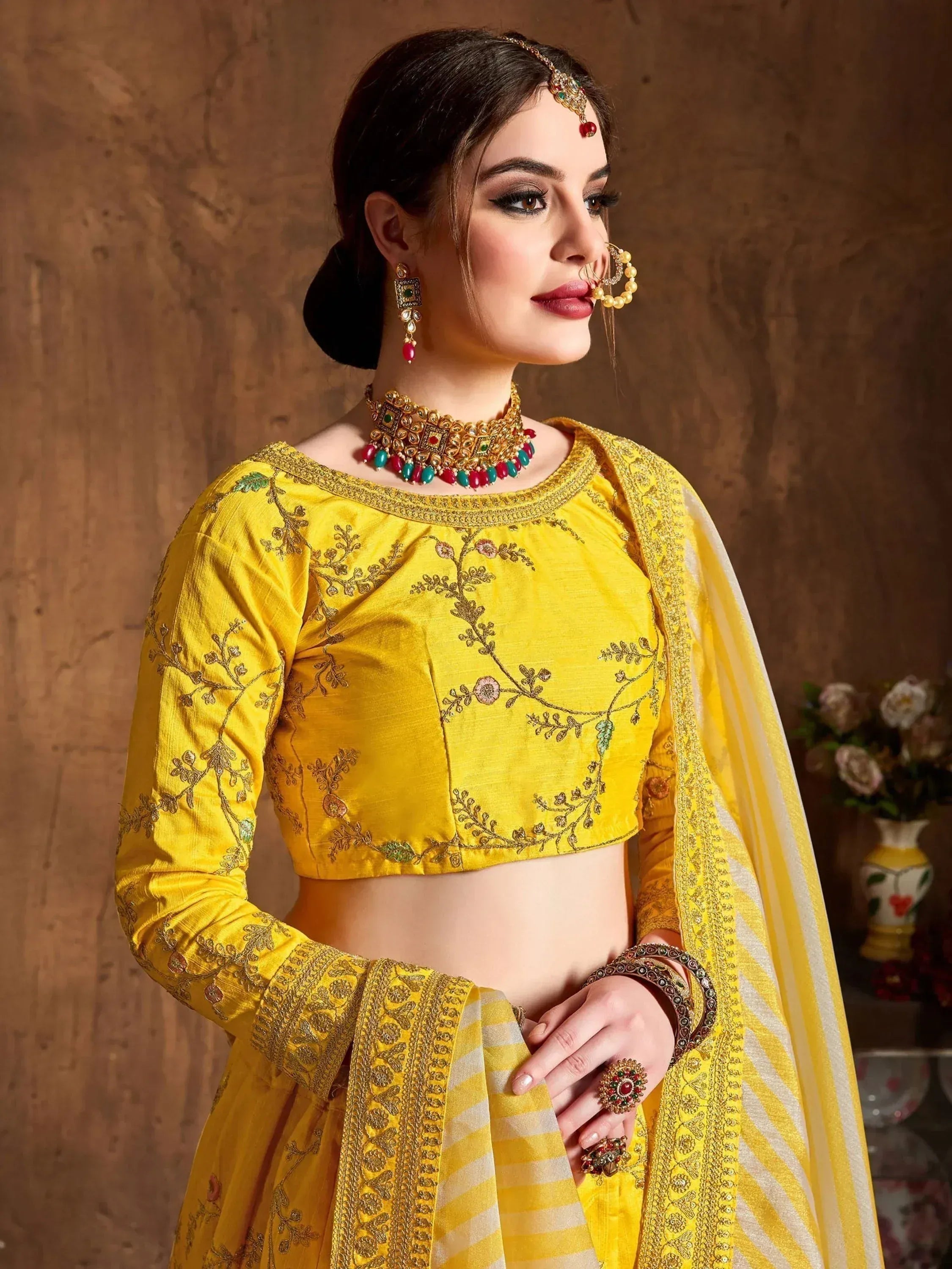 Yellow embroidered lehenga choli with floral motifs, traditional Indian ethnic wear for weddings and festivals