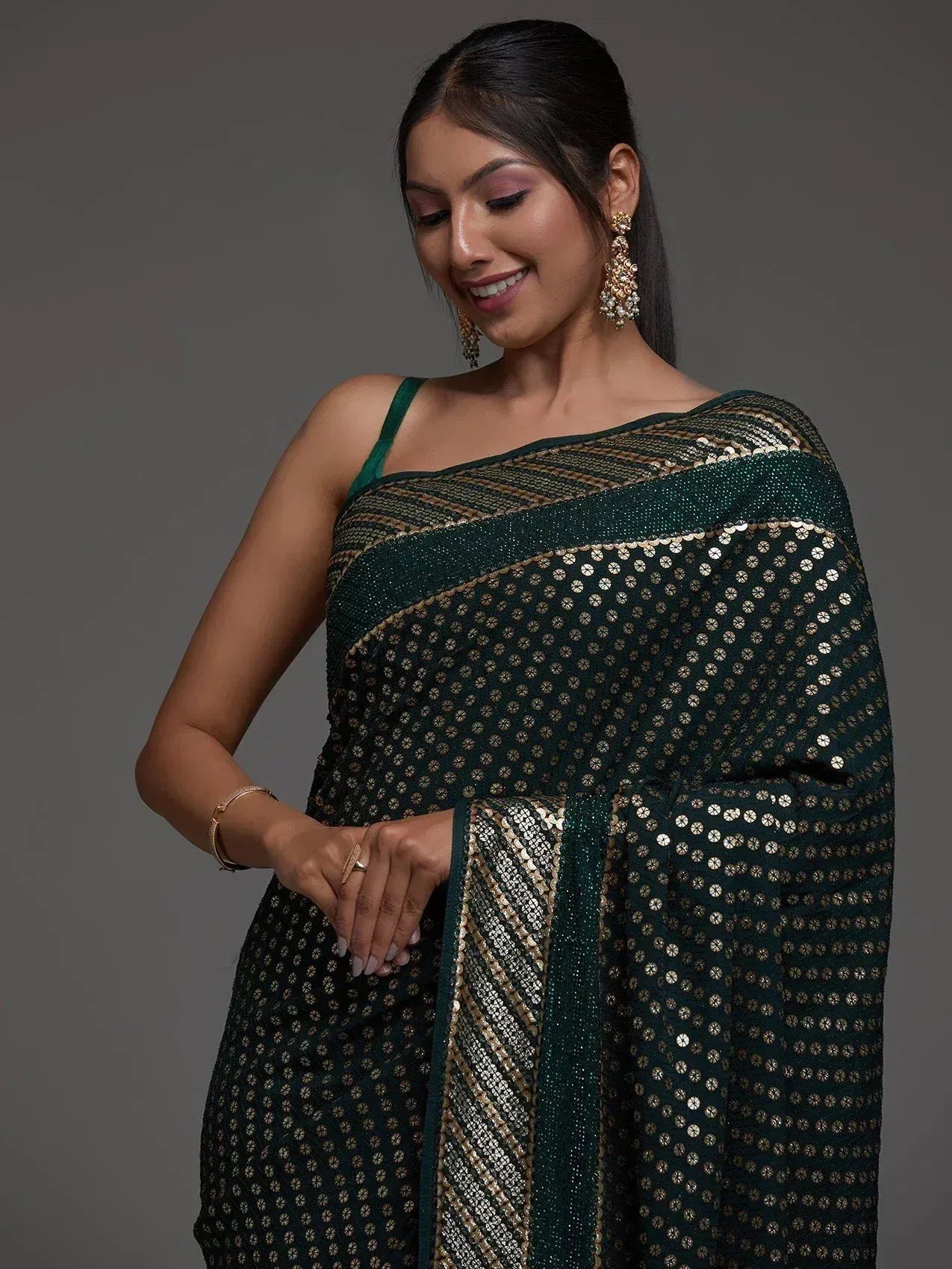 Elegant green saree with gold sequin detailing, perfect for ethnic occasions
