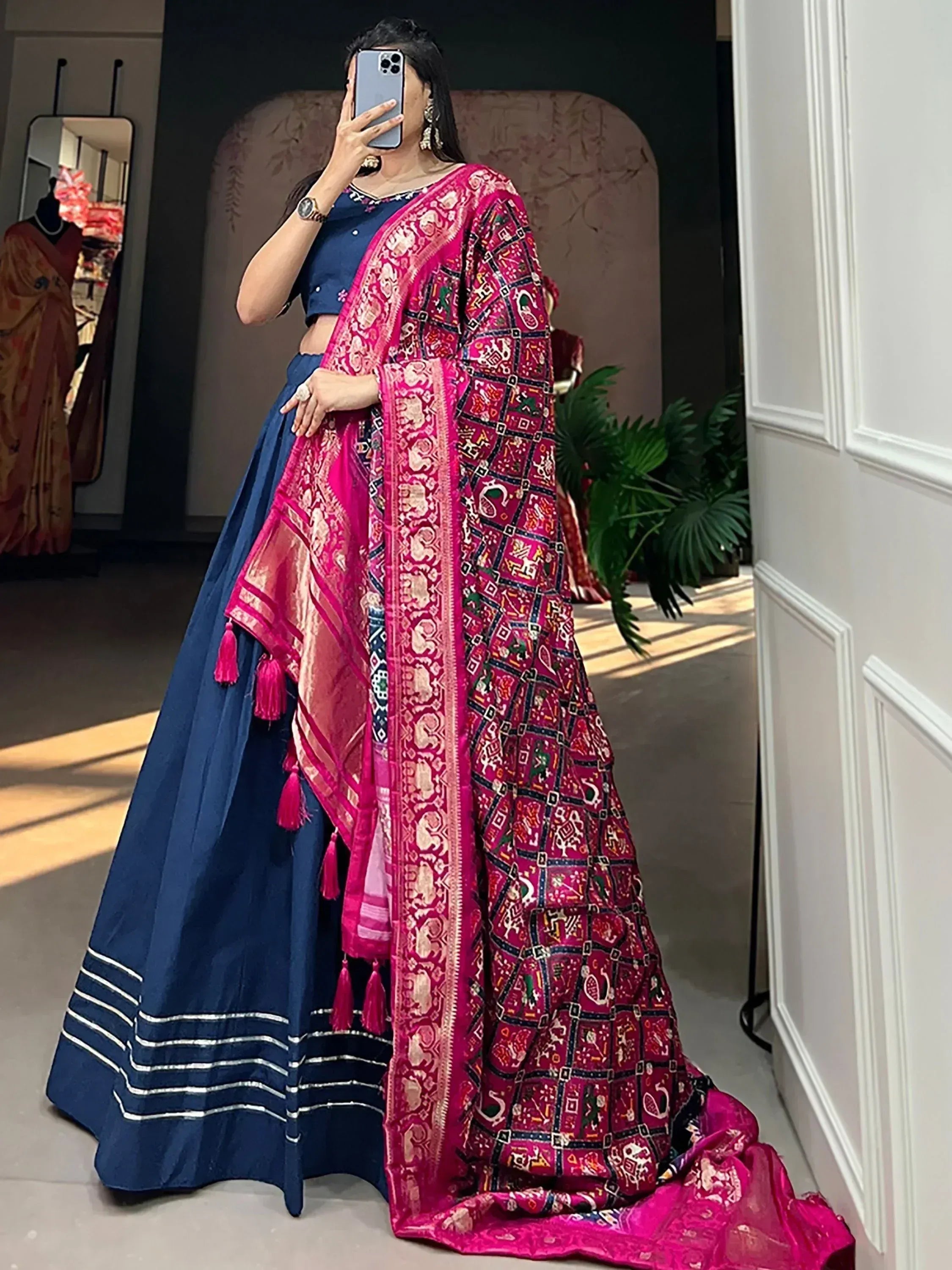 Woman in navy blue lehenga choli with vibrant pink printed dupatta, ethnic Indian wear