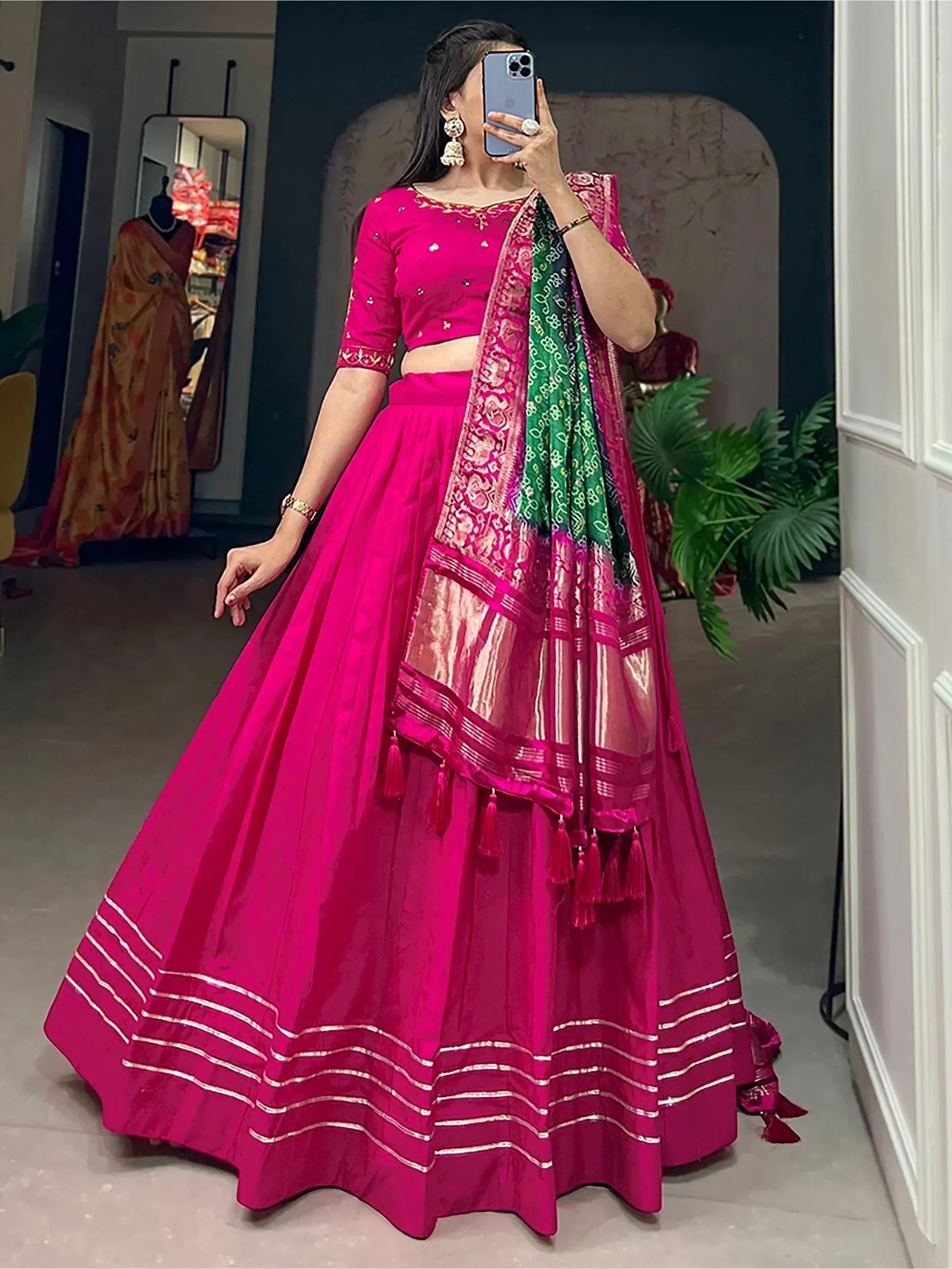 Fuchsia lehenga choli with embroidered blouse, pleated skirt, and green-pink dupatta for Indian ethnic wear