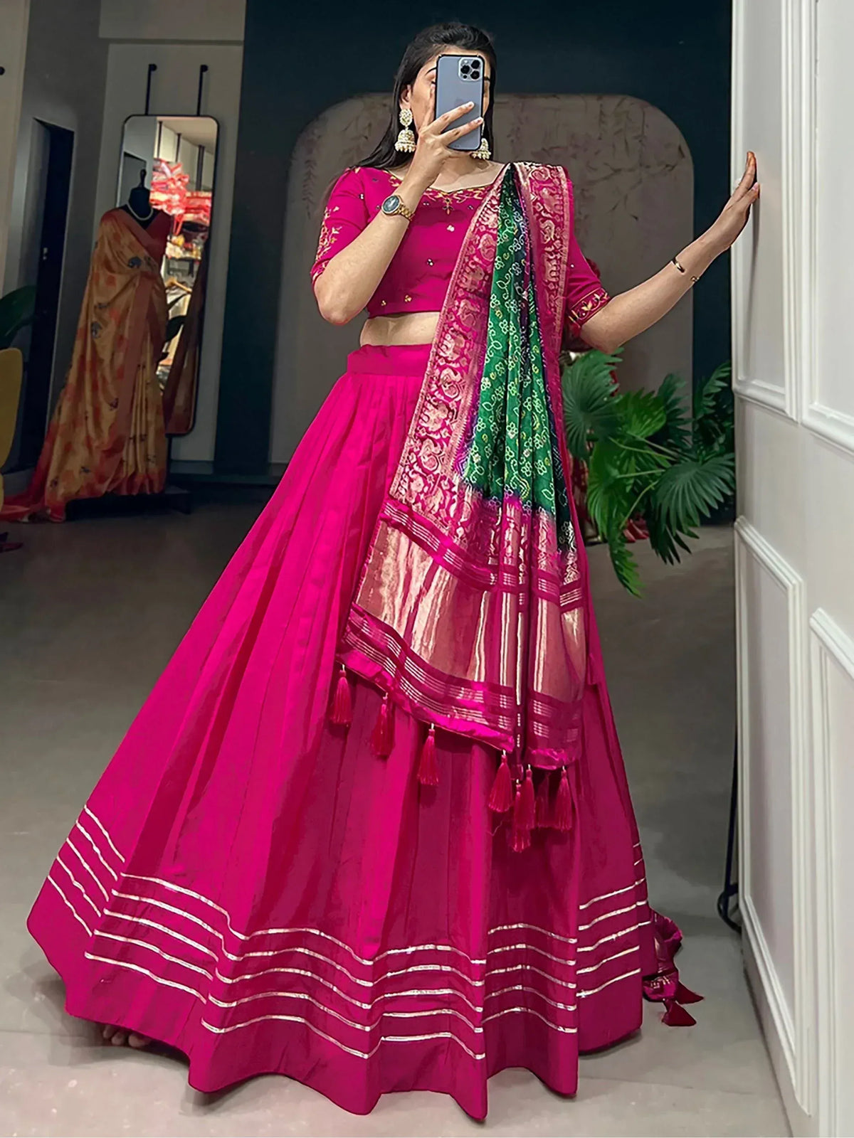 Vibrant pink lehenga choli with embroidered blouse, layered skirt, and green-pink dupatta for Indian ethnic wear