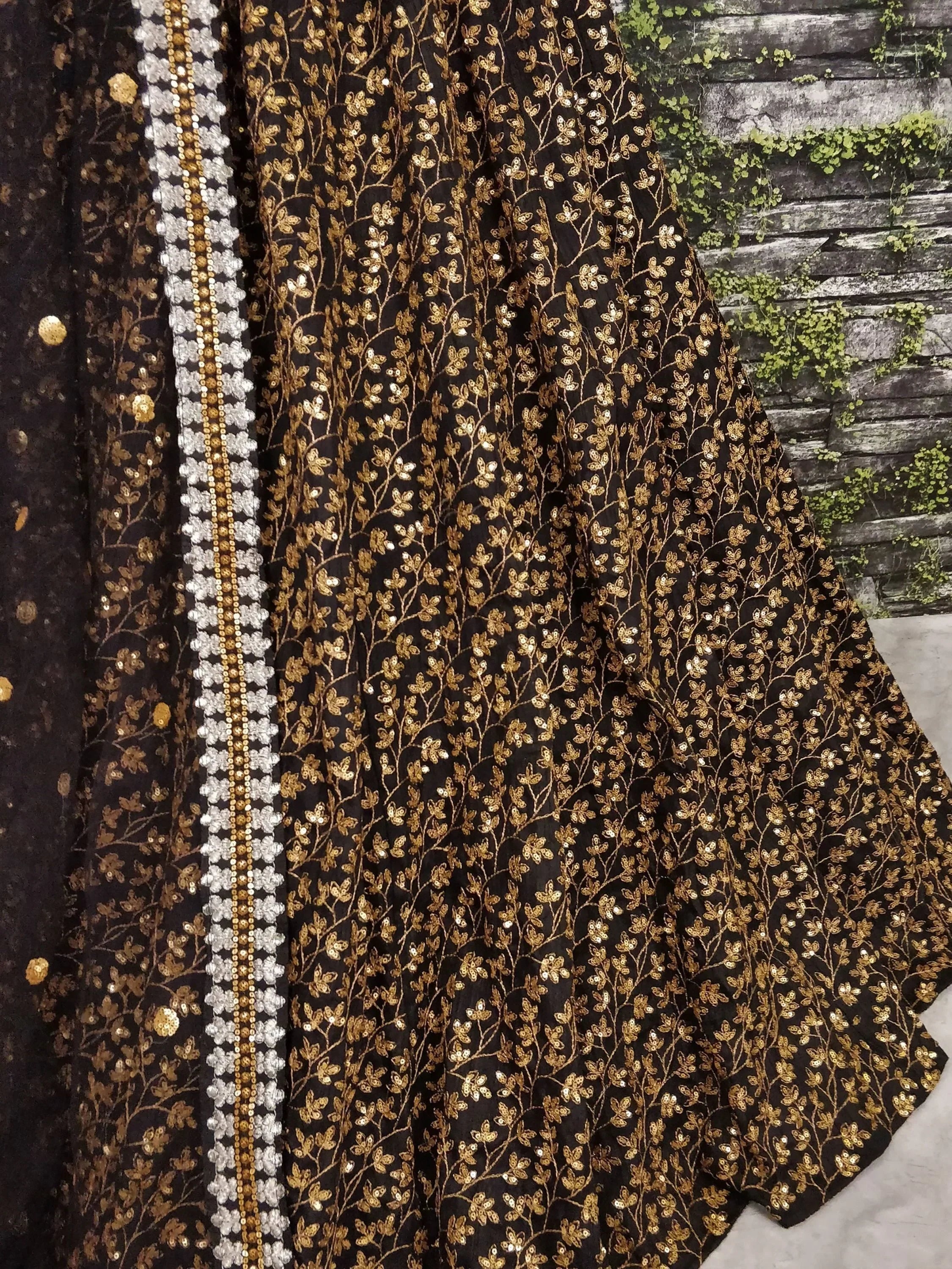 Black and gold embroidered lehenga with floral sequin work and silver border, ideal for Indian ethnic wear