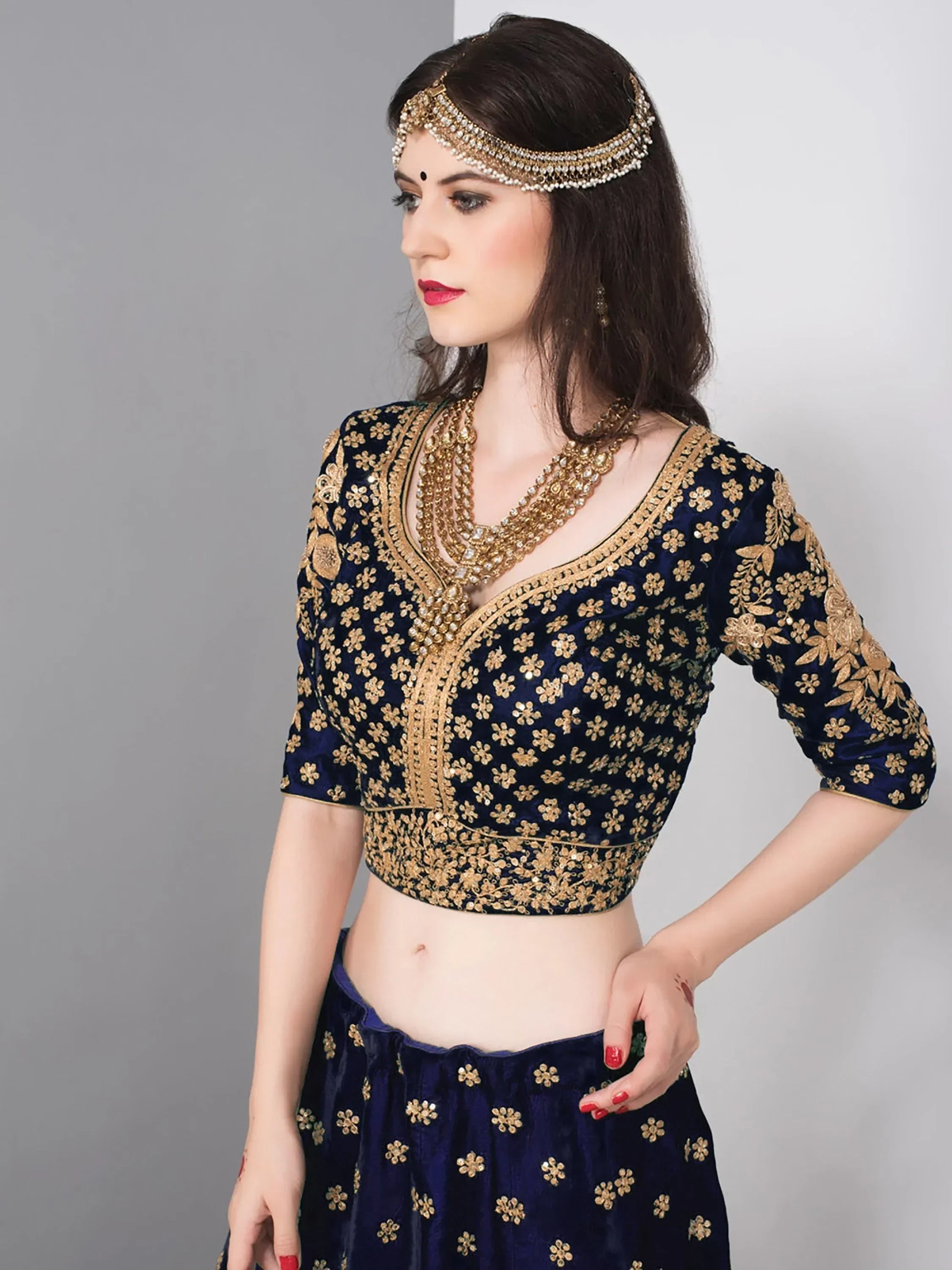 Elegant navy blue lehenga choli with gold floral embroidery and matching jewelry