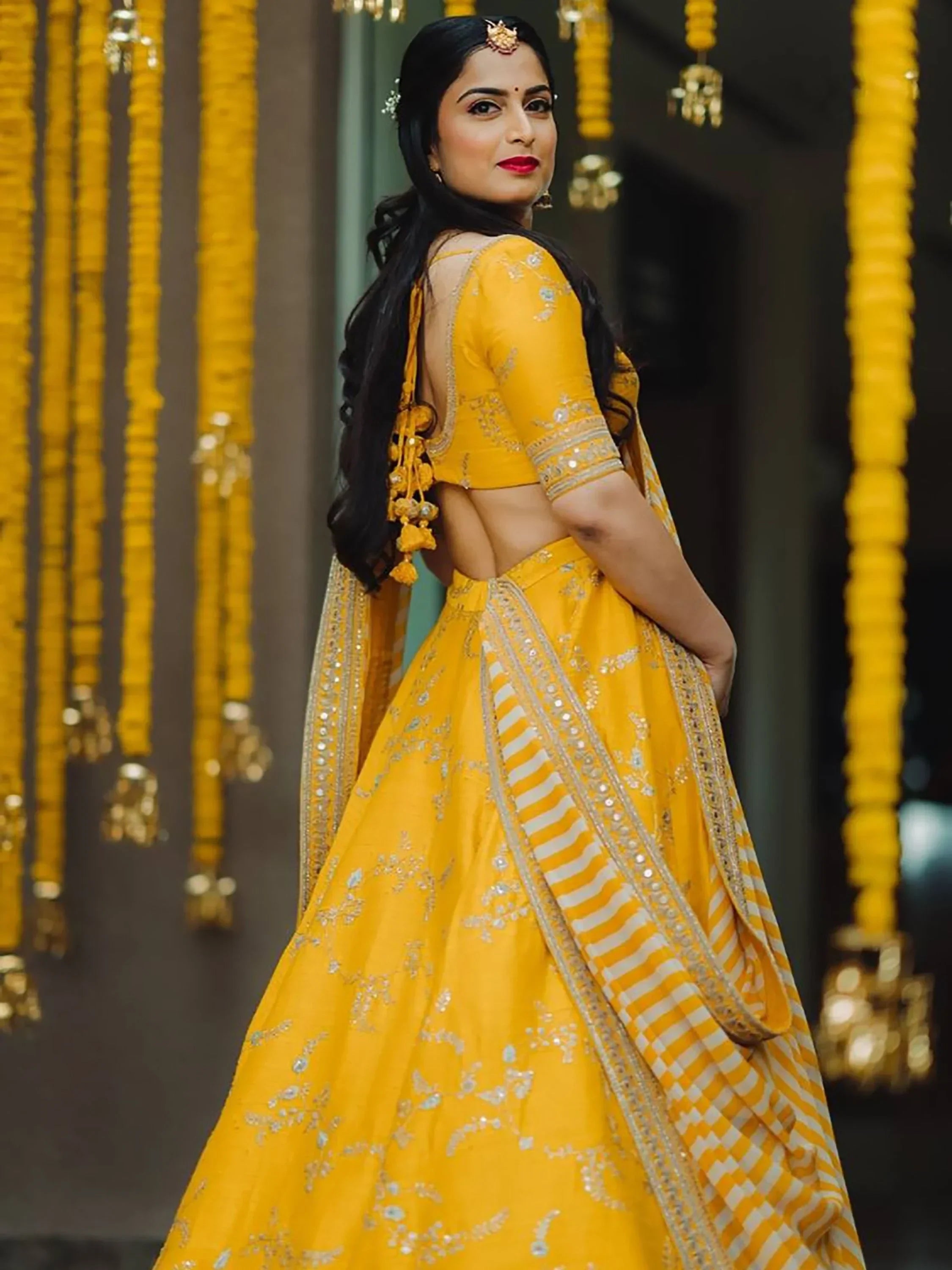 Yellow designer lehenga choli with backless blouse, perfect for Indian weddings and festive occasions