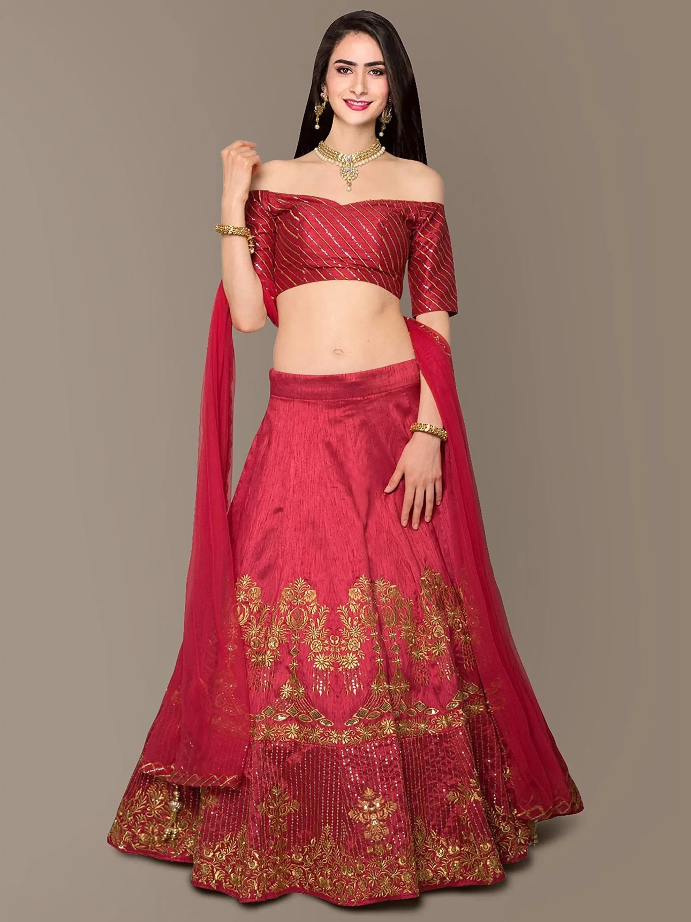 Red off-shoulder lehenga choli with gold embroidery, perfect for Indian weddings and festive occasions.