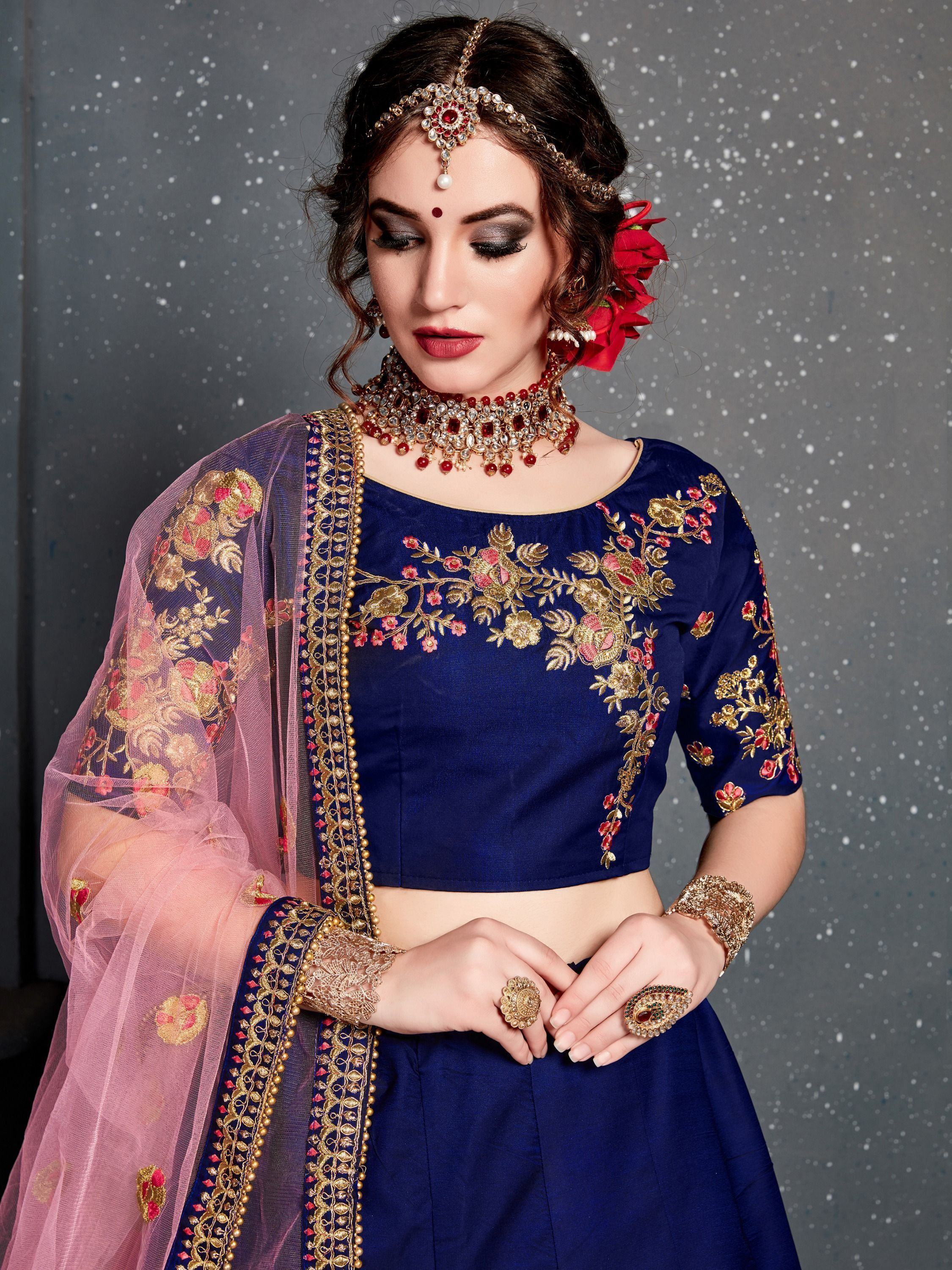 Navy blue embroidered lehenga choli with pink dupatta, floral gold work, and traditional Indian jewelry