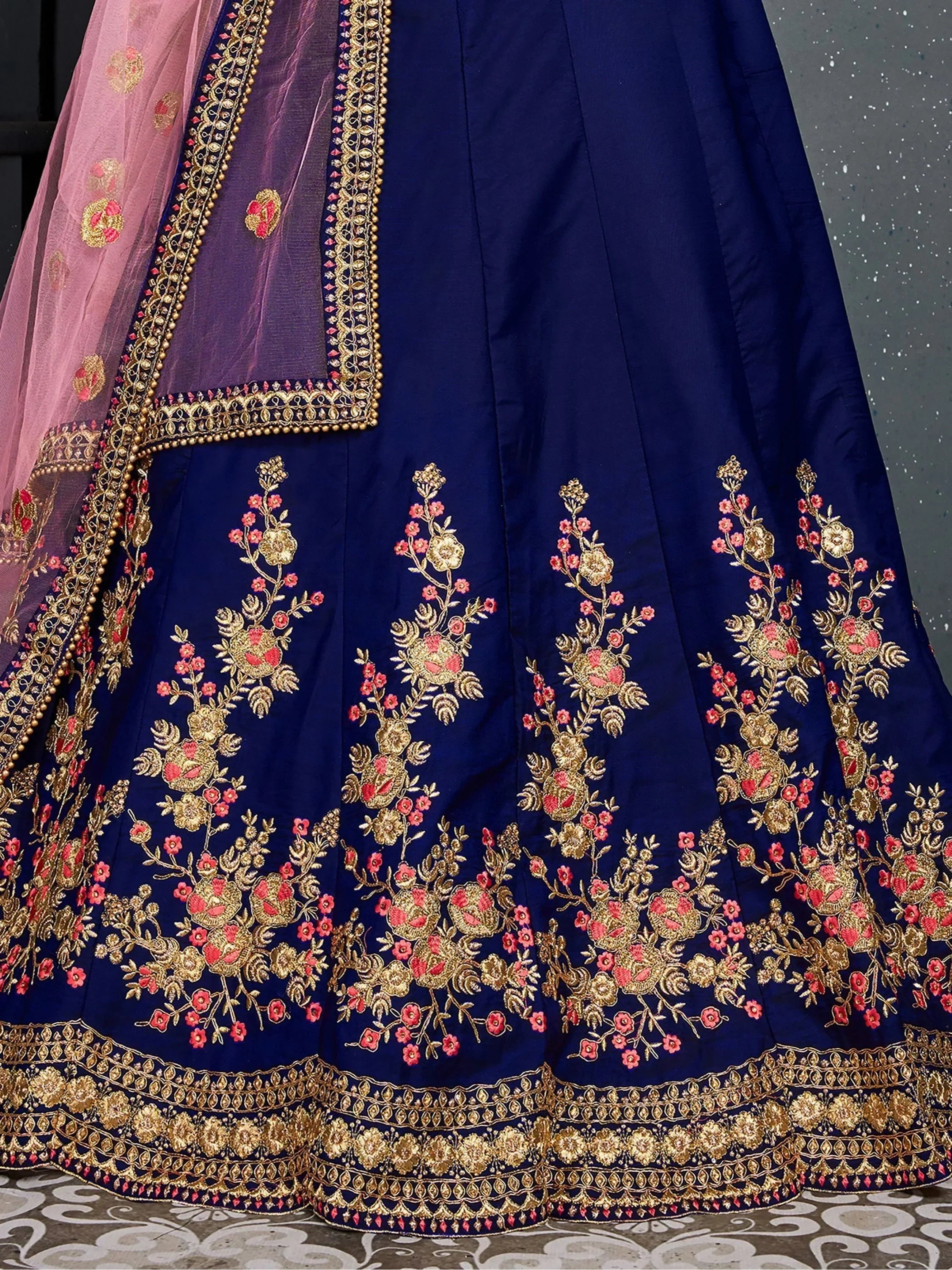 Navy blue lehenga with gold and pink floral embroidery, paired with sheer pink dupatta for Indian ethnic wear