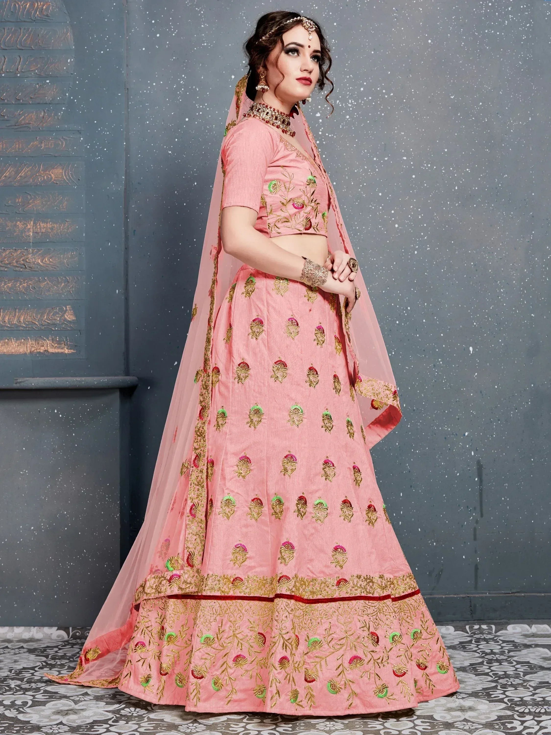 Pink embroidered lehenga choli with floral motifs, perfect for Indian weddings and festive occasions.