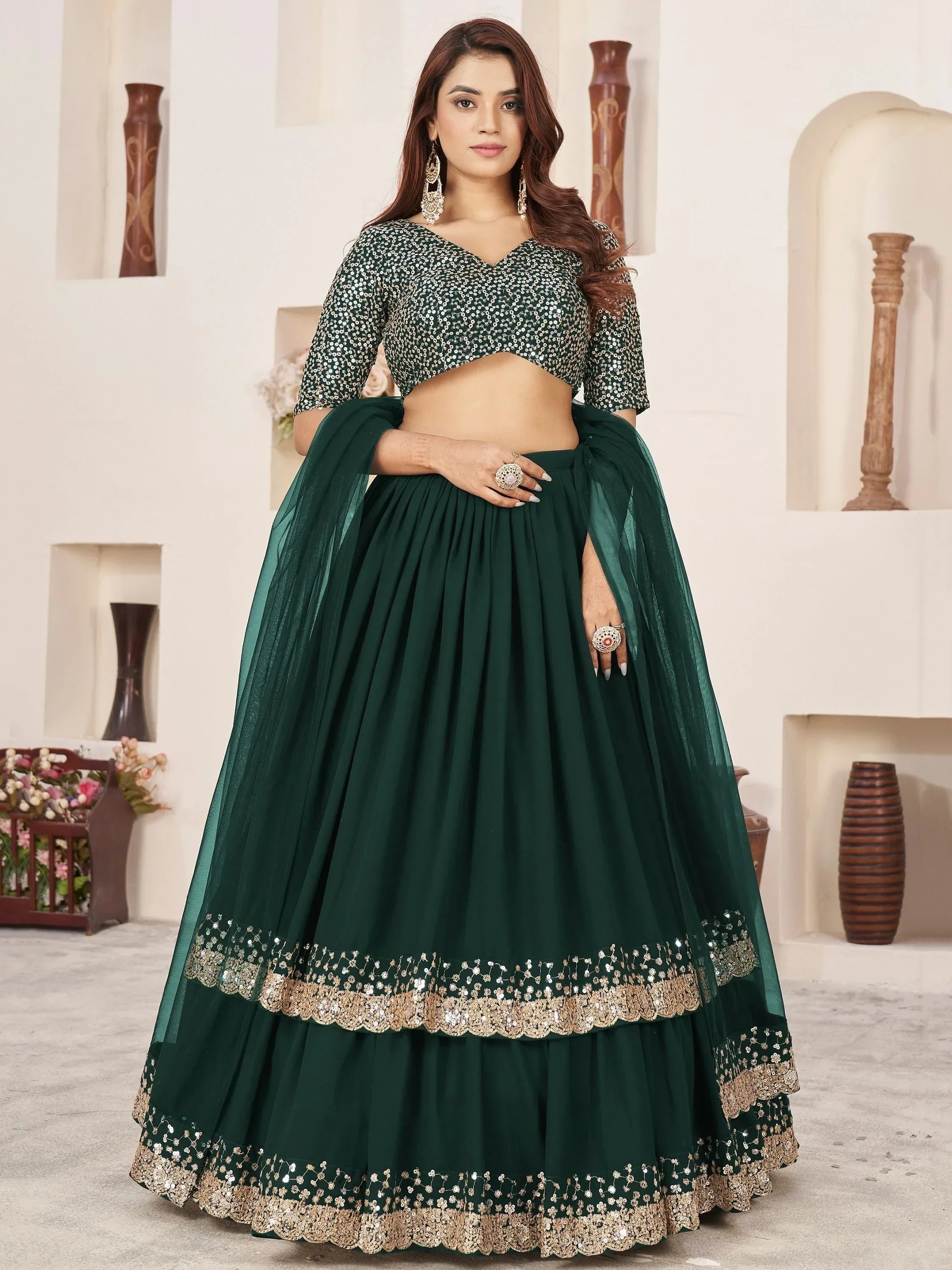 Emerald green designer lehenga choli with sequin blouse and gold embroidery, perfect for Indian ethnic occasions.
