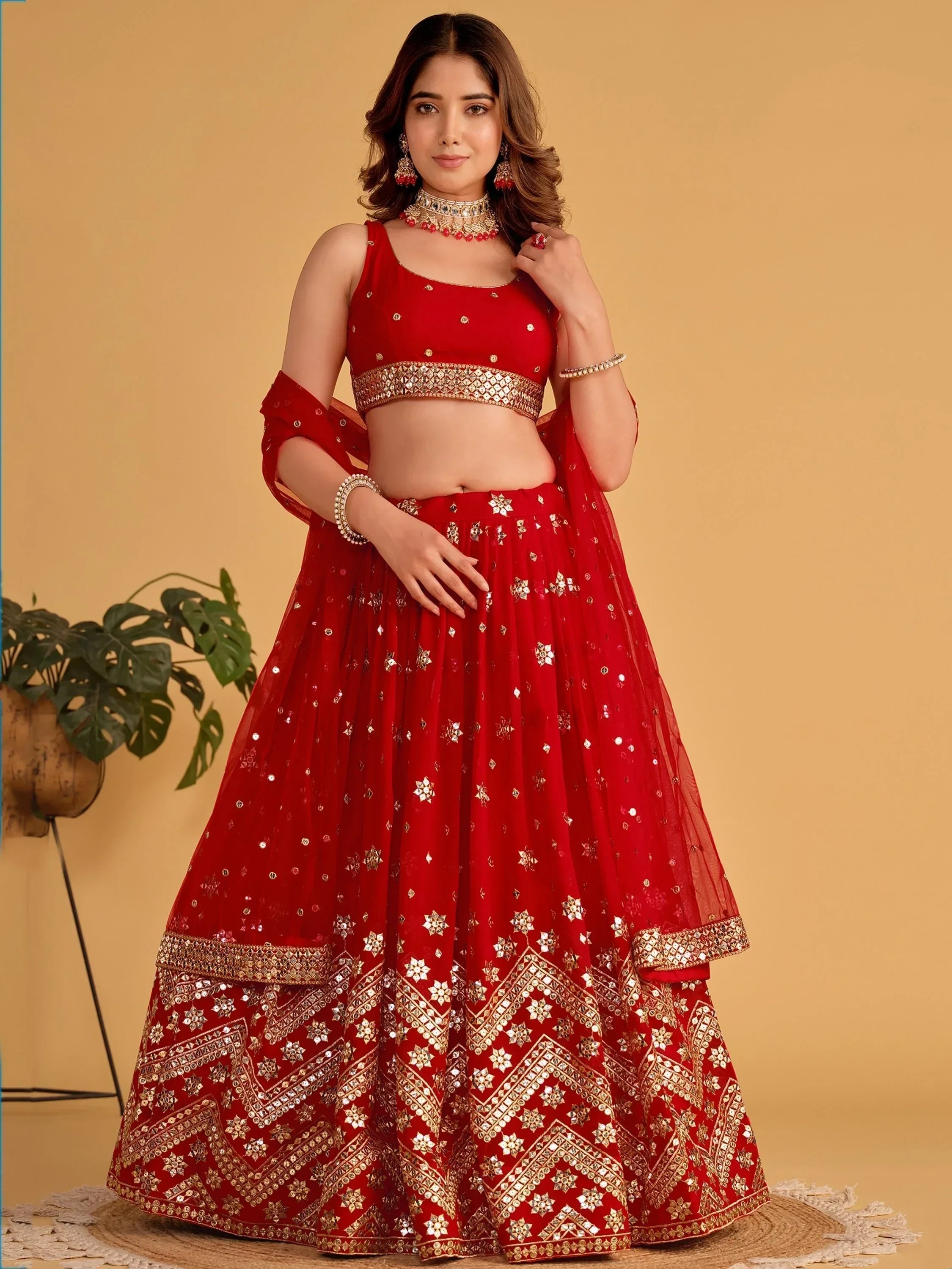 Red designer lehenga choli with gold mirror work, perfect for Indian weddings and festive occasions